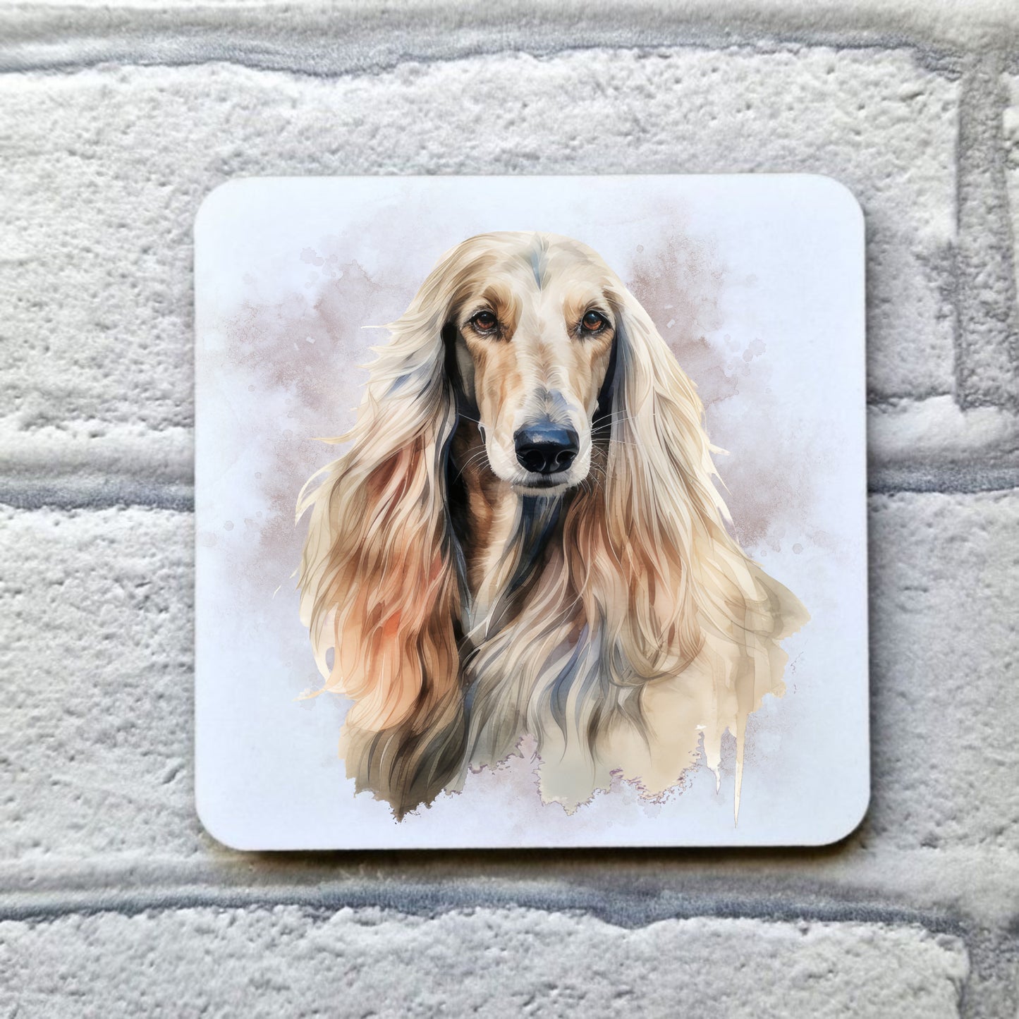 An Afghan Hound with long flowing hair on a smoky background. This image is on a white drinks coaster. The coaster is placed on a grey, brick effect surface.