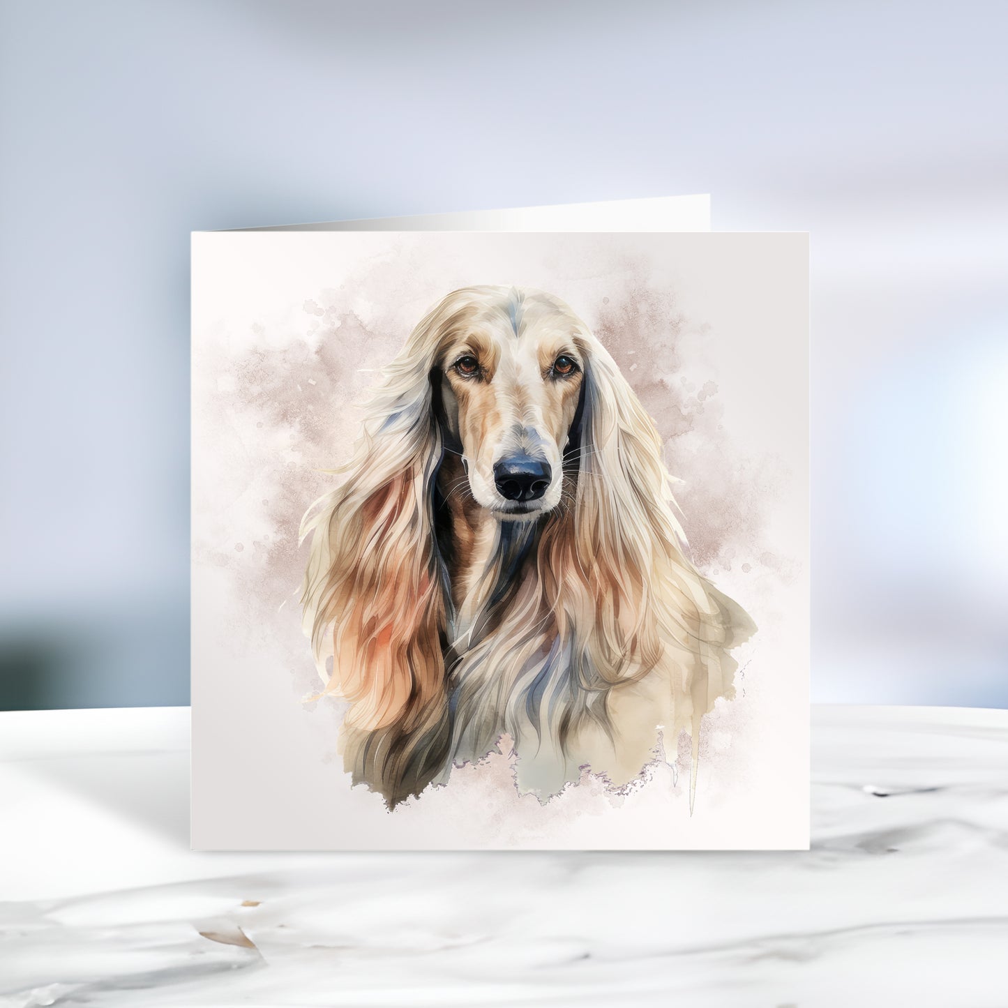Afghan Hound head shot facing forward with a smokey brown background on a white card. The card is placed on a grey marble surface.