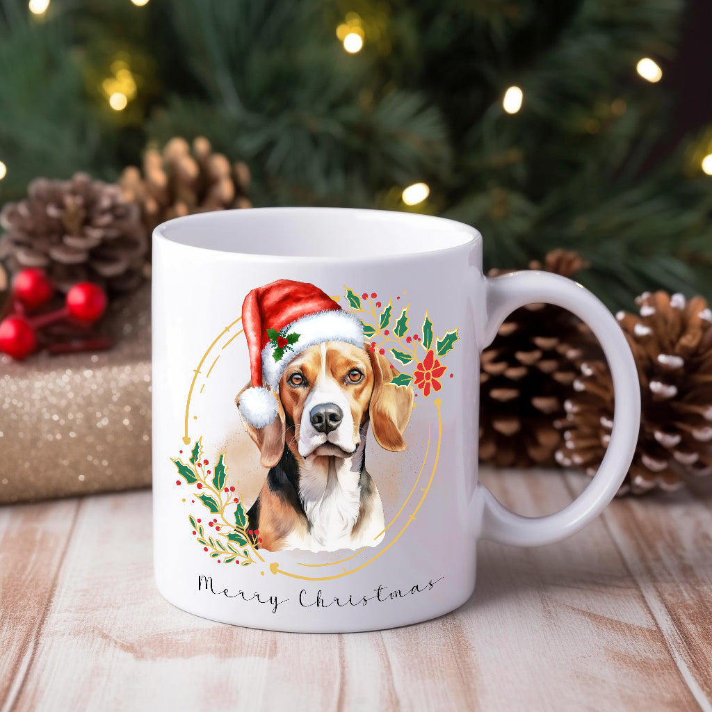 A white ceramic mug with a watercolour design of a beagle wearing a Santa hat, placed on a wooden surface with Christmas decorations around.