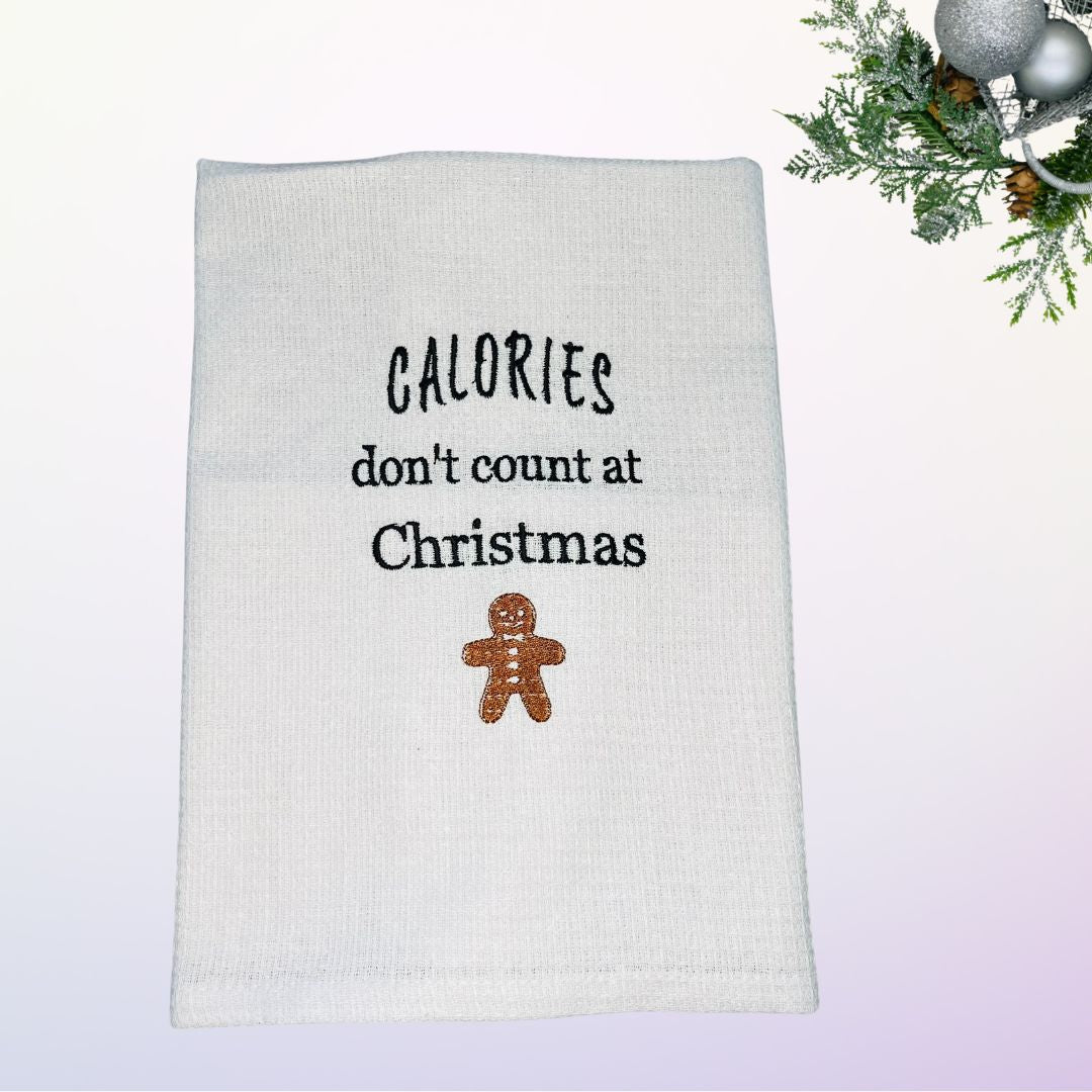 Image of Christmas tea towel with embroidered gingerbread man and the slogan calories don't count at Christmas
