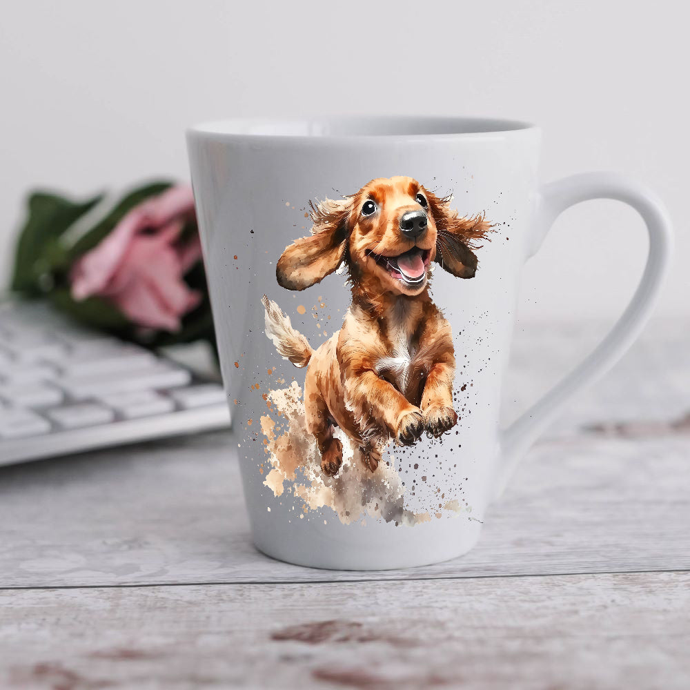 A white 12oz ceramic latte mug with a printed image of a running Dachshund. A computer keyboard sits in the background. The mug is positioned on a grey wooden surface.