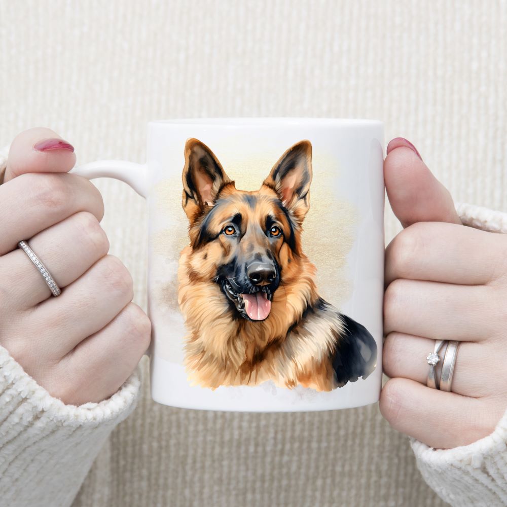 A German Shepherd dog with a very alert expression adorns this white ceramic mug. A gold misty background decorates the mug which is being held by a woman with both hands.