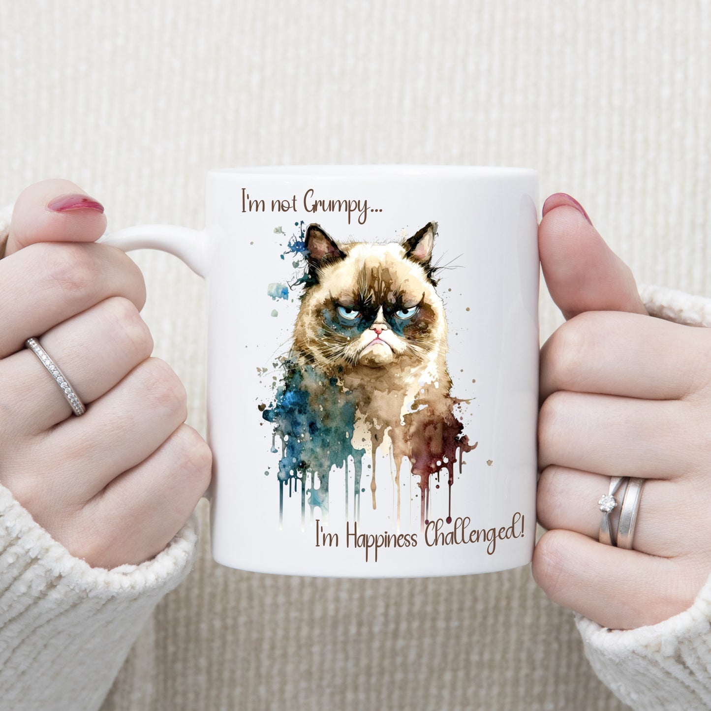 Woman holding a white ceramic mug with the image of Grumpy cat and a quote. Image decorated with splashes and paint runs.