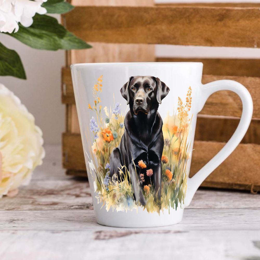 A 12oz white ceramic latte mug with a printed image of a black Labrador dog, positioned on a wooden surface with a blurred background.