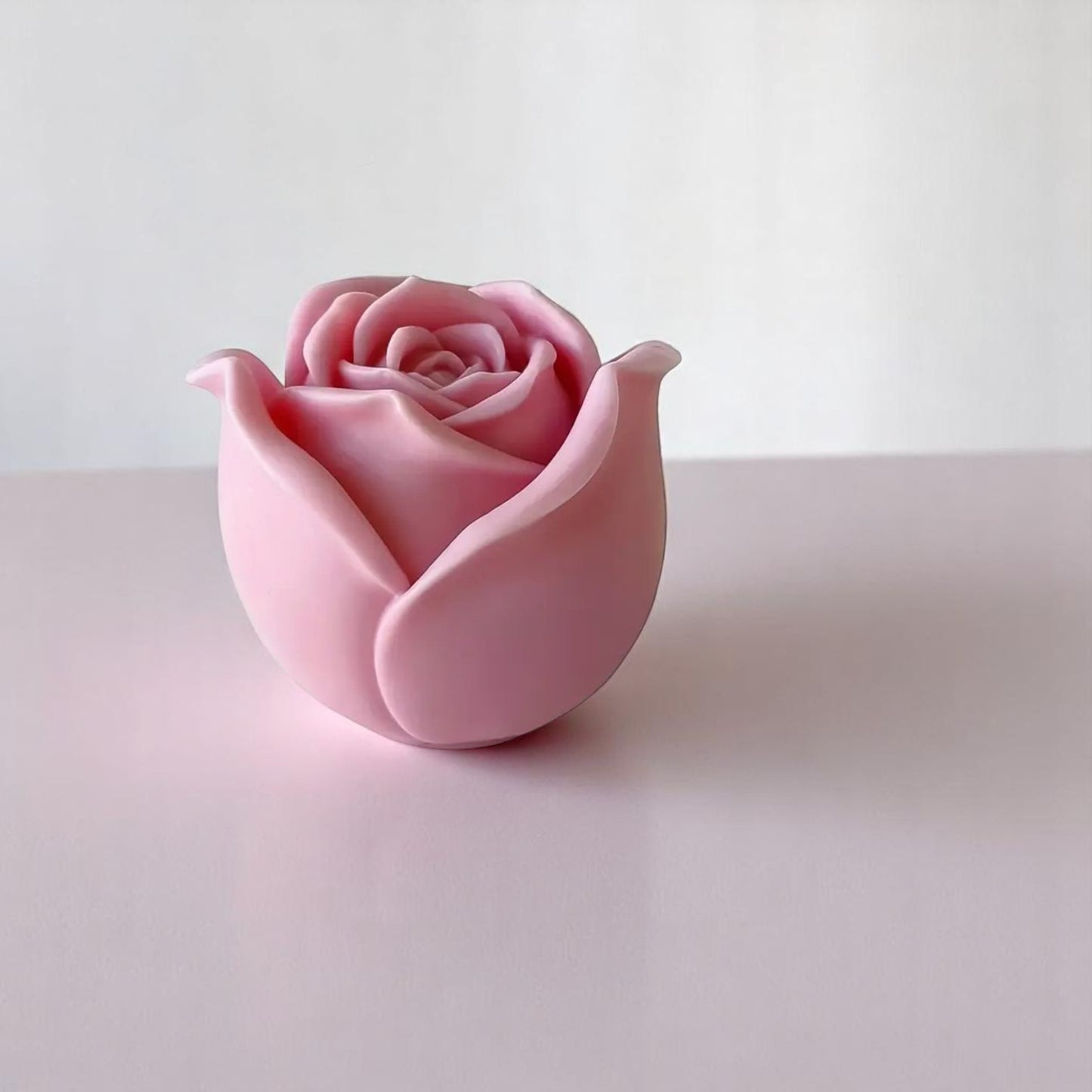 Pink rose-shaped wax melt object on a white background