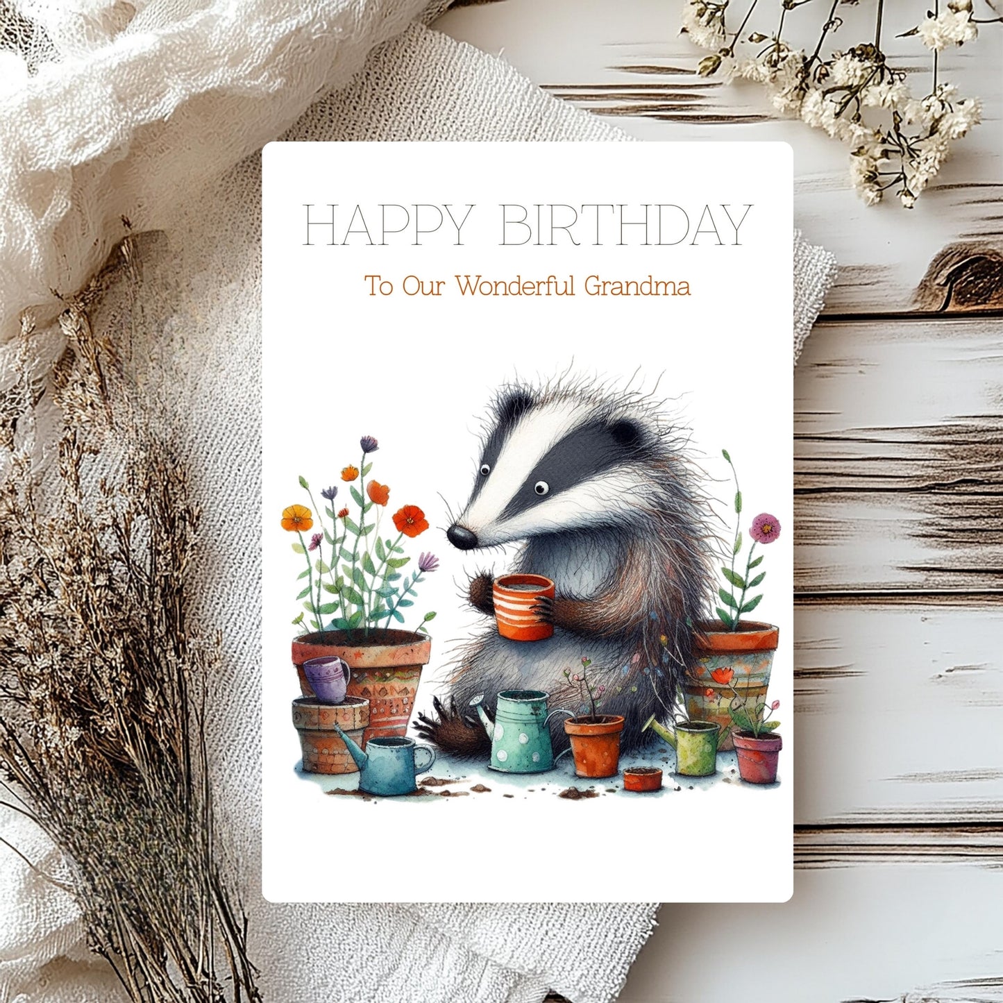 Birthday card with a badger and potted plants on a wooden surface