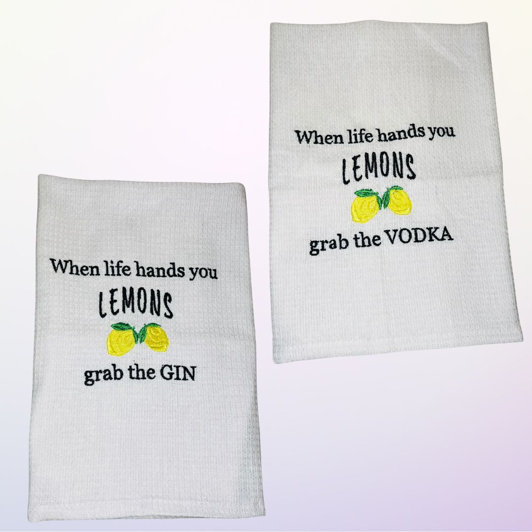 Close up of gin related tea towels with the slogan "when life hands you lemons grab the vodka"
