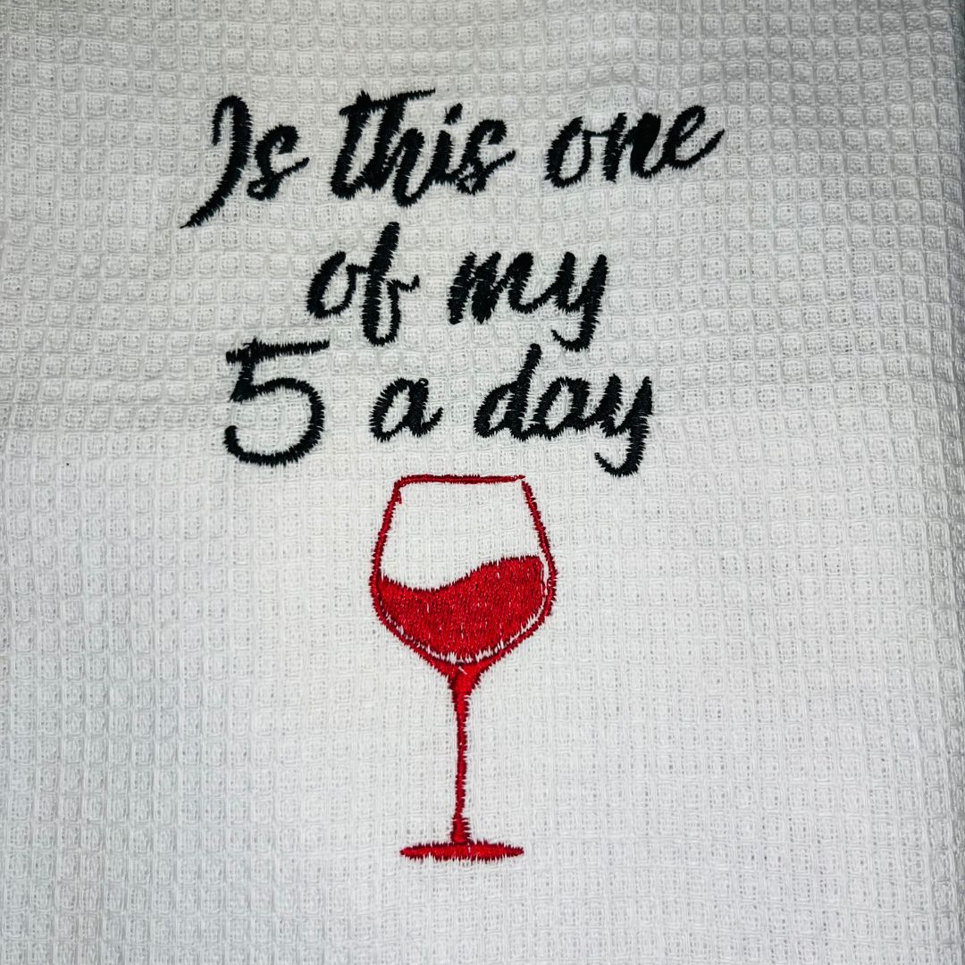 close up of waffle tea towel with the slogan "is this one of my 5 a day" with a wine glass embroidered