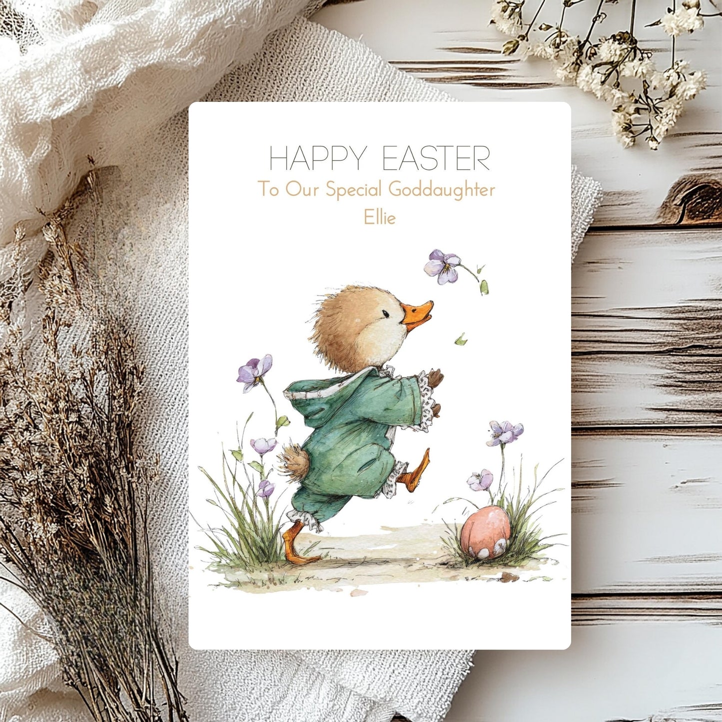 Easter card with a duckling and flowers on a wooden surface