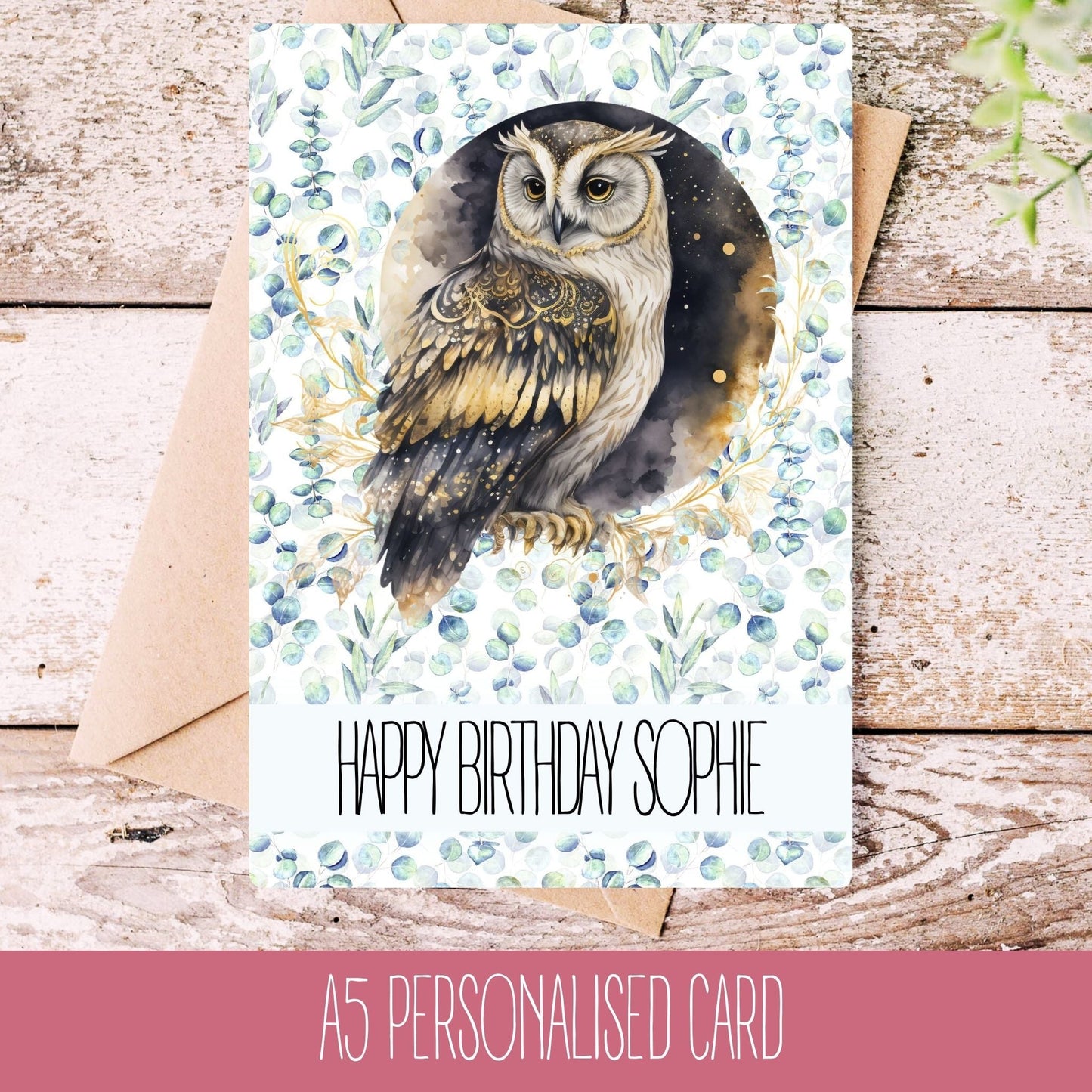 A personalised handmade greeting card with an owl illustration, featuring the text 'Happy Birthday Sophie'. The card is placed on a wooden surface with a white envelope beside it.