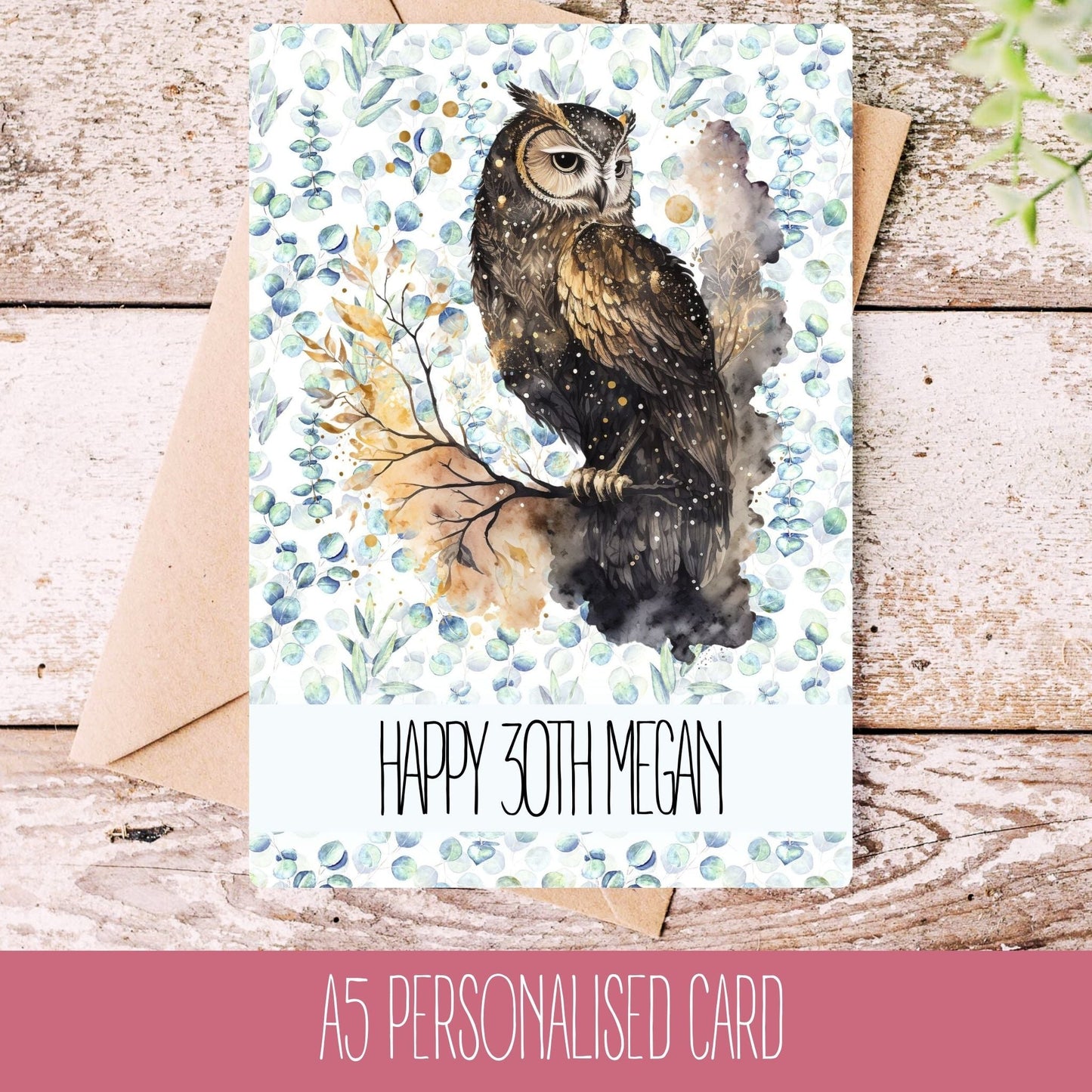 A personalised handmade greeting card with an owl illustration, featuring text 'HAPPY 30TH MEGAN' on the front, placed on a wooden background with a white envelope.