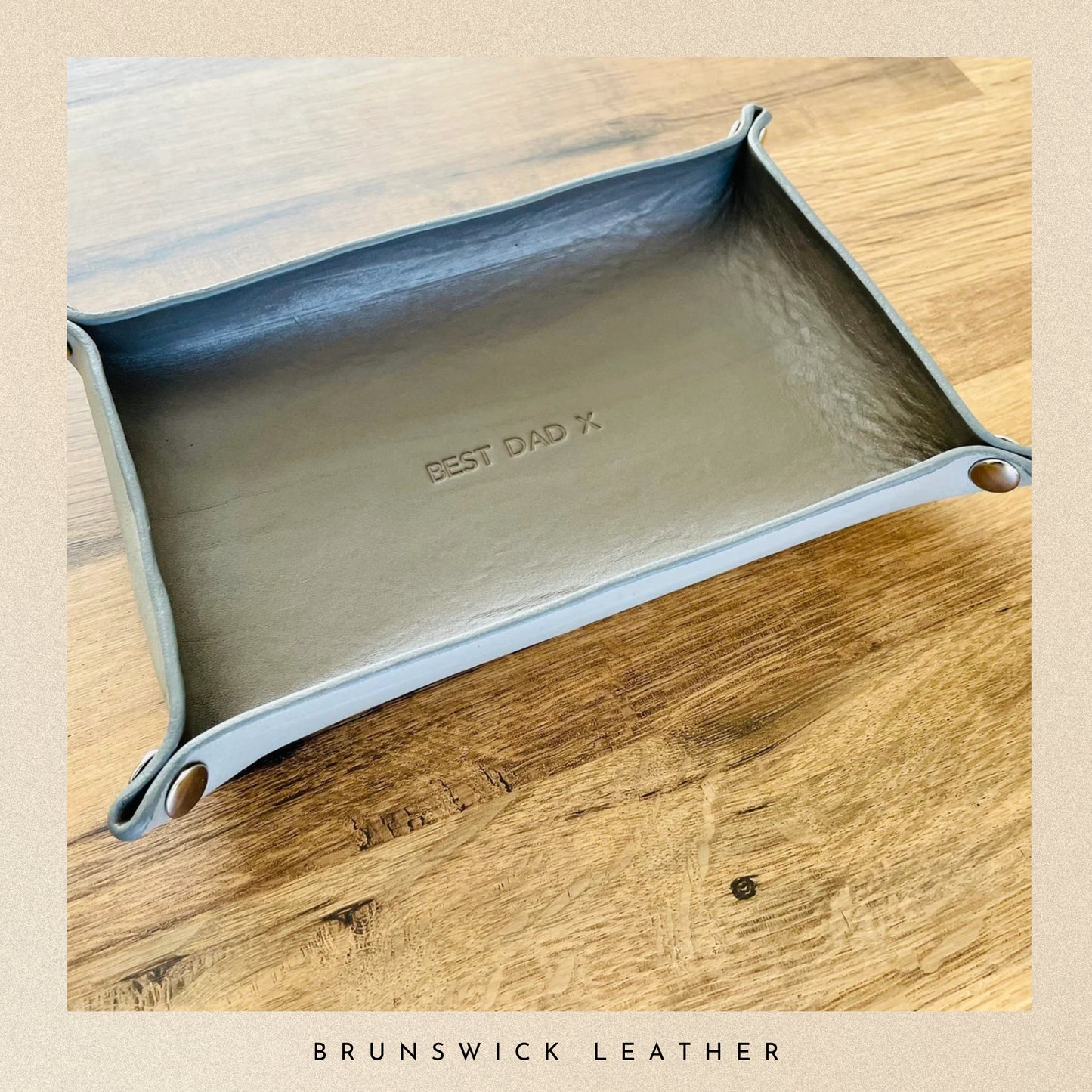 Leather tray with 'Best Dad' engraving on a wooden surface, branded 'Brunswick Leather'.