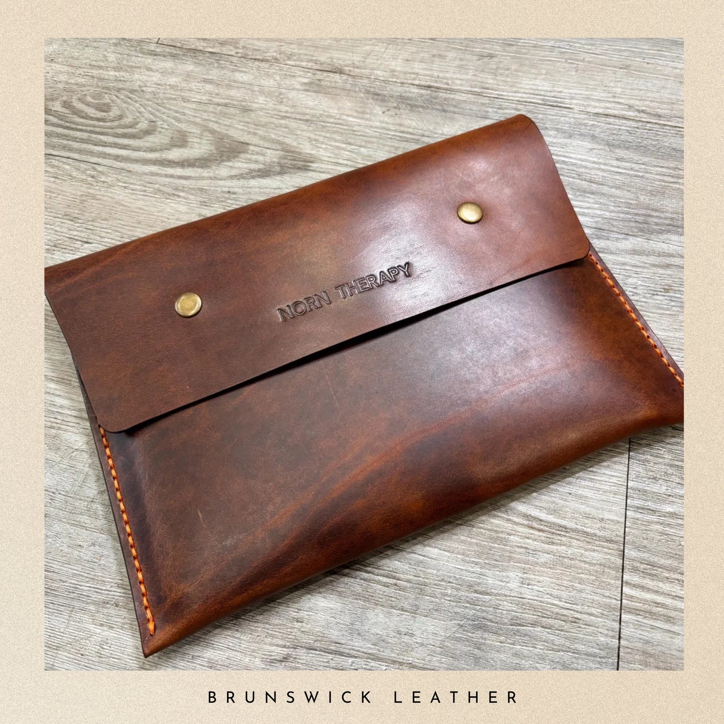 Brown leather pouch with 'Brunswick Leather' branding on a wooden surface