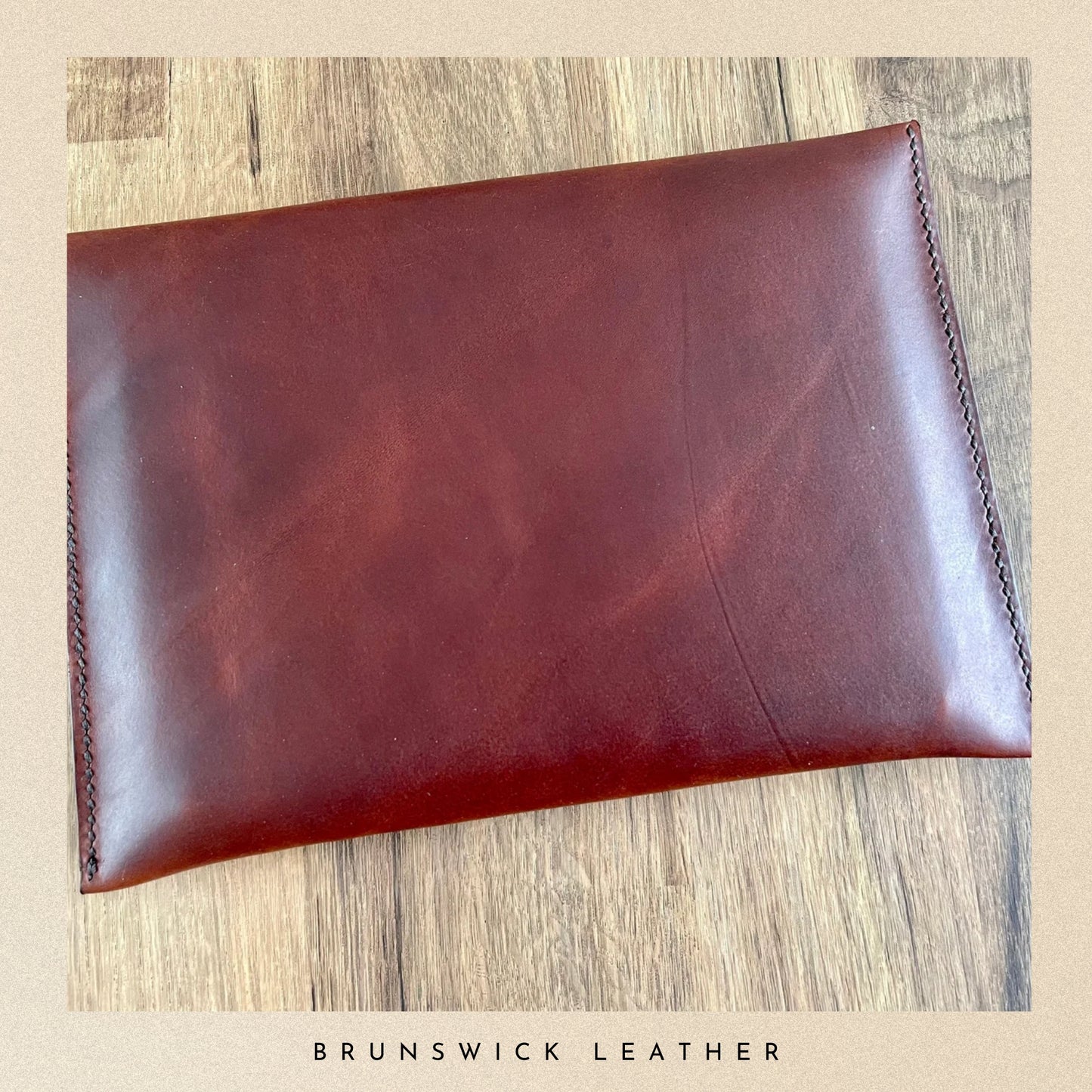 Brown leather pouch on a wooden surface with 'Brunswick Leather' branding.