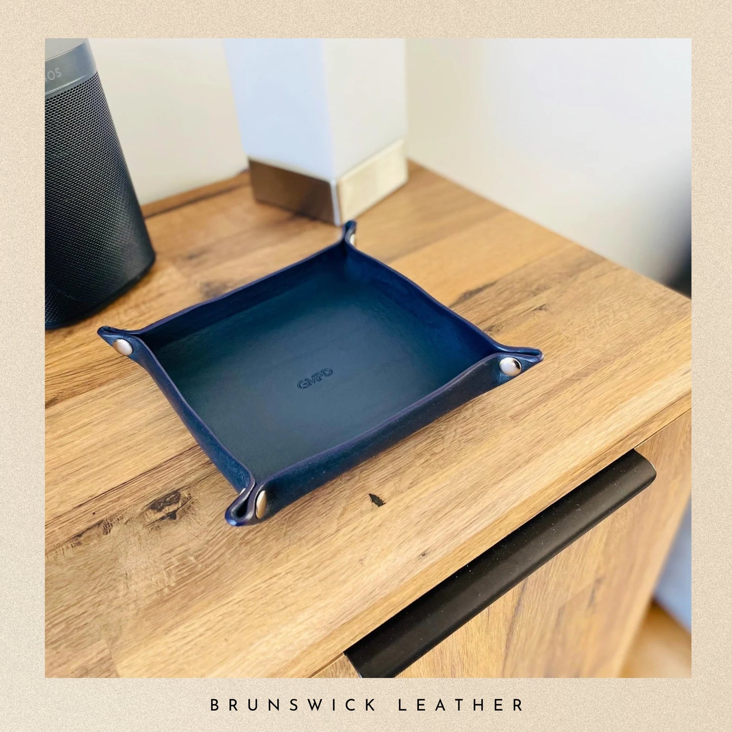 Blue leather tray on a wooden surface with 'Brunswick Leather' branding.
