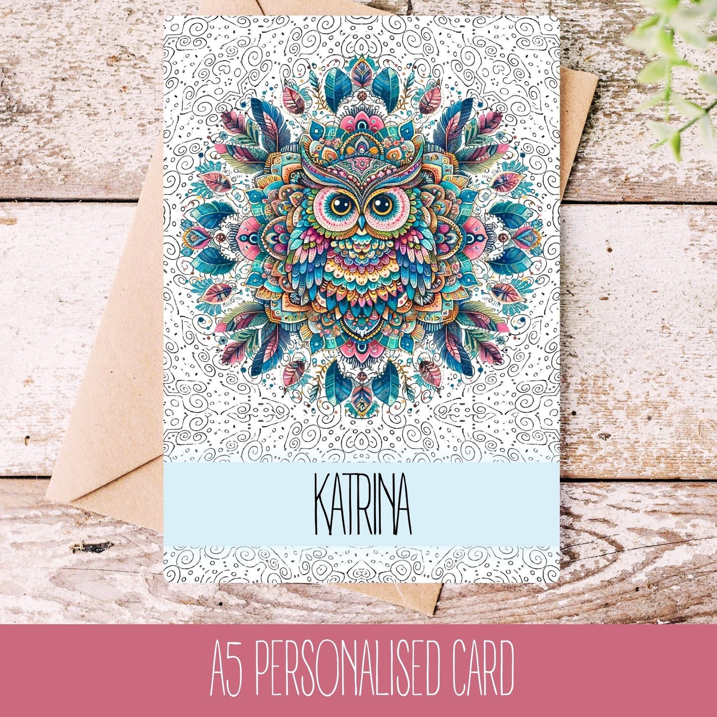 A personalised birthday card with a mandala owl design, featuring the name Katrina, laid on a wooden background with a white envelope.