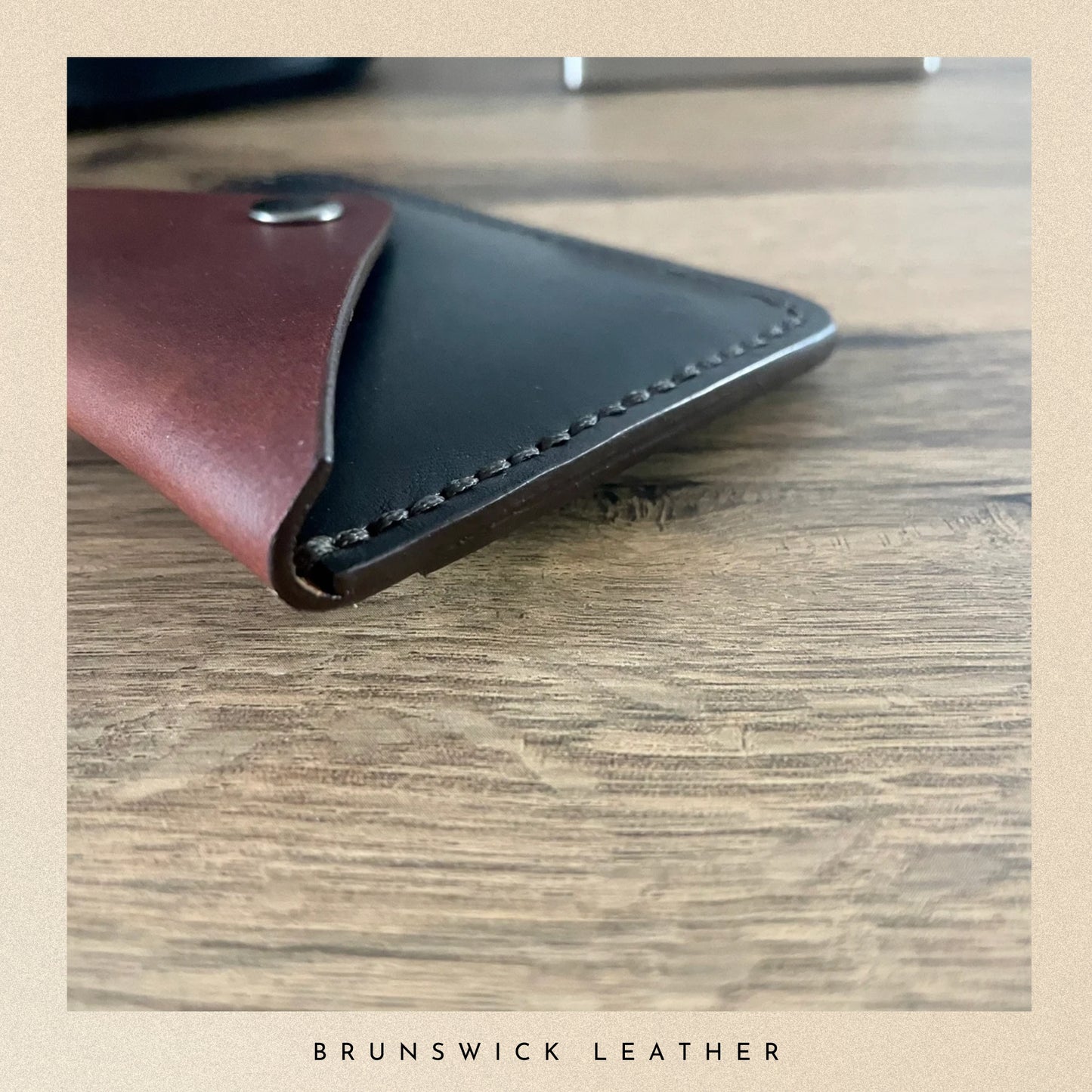 Leather wallet on a wooden surface with 'Brunswick Leather' branding.