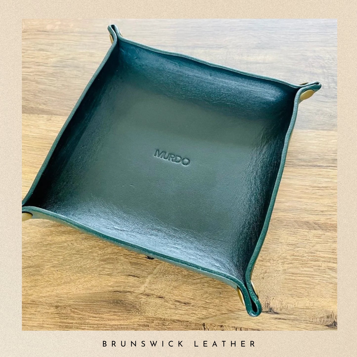Teal leather tray with 'MURDO' branding on a wooden surface, featuring Brunswick Leather.