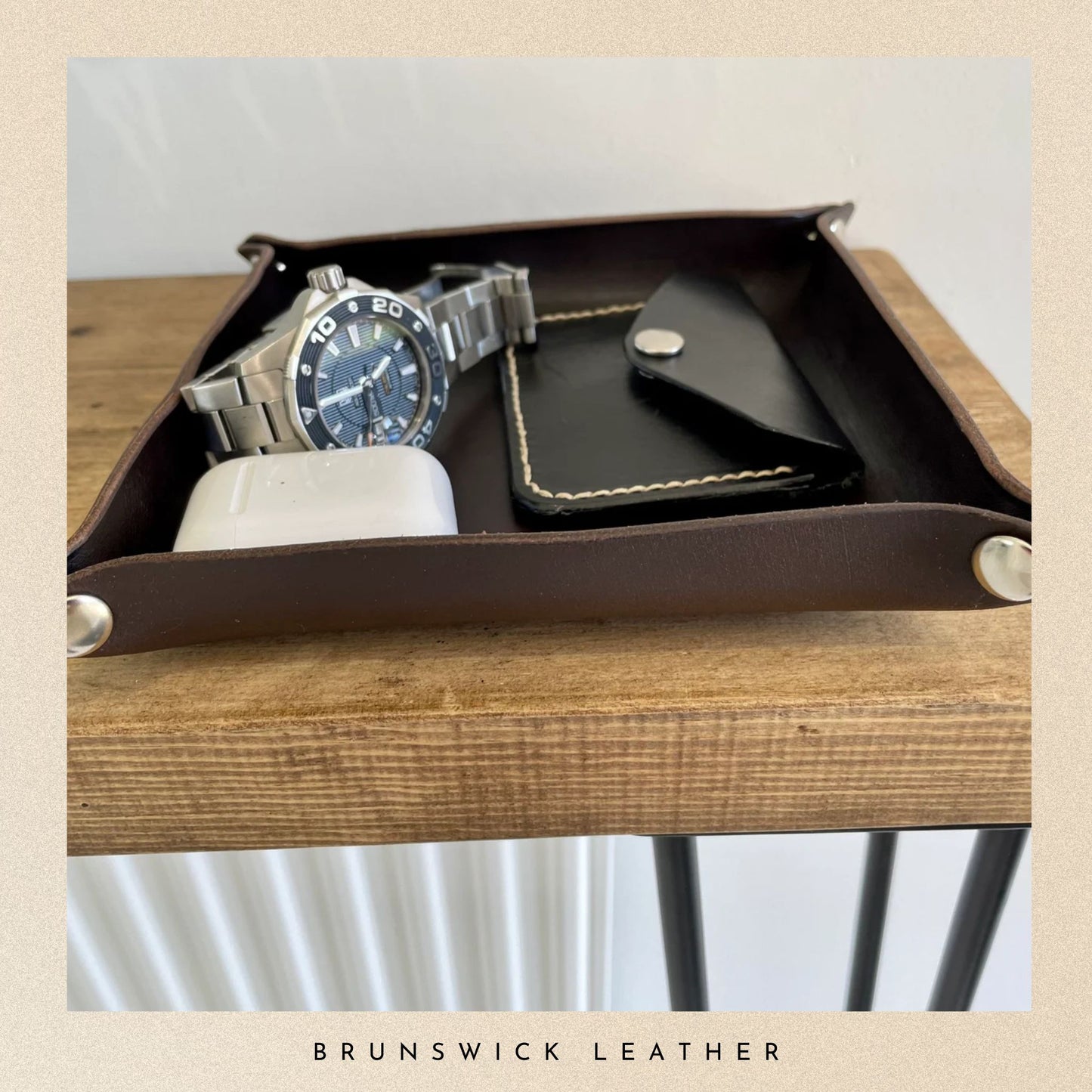 Leather tray with a watch, mug, and wallet on a wooden surface with 'Brunswick Leather' branding.