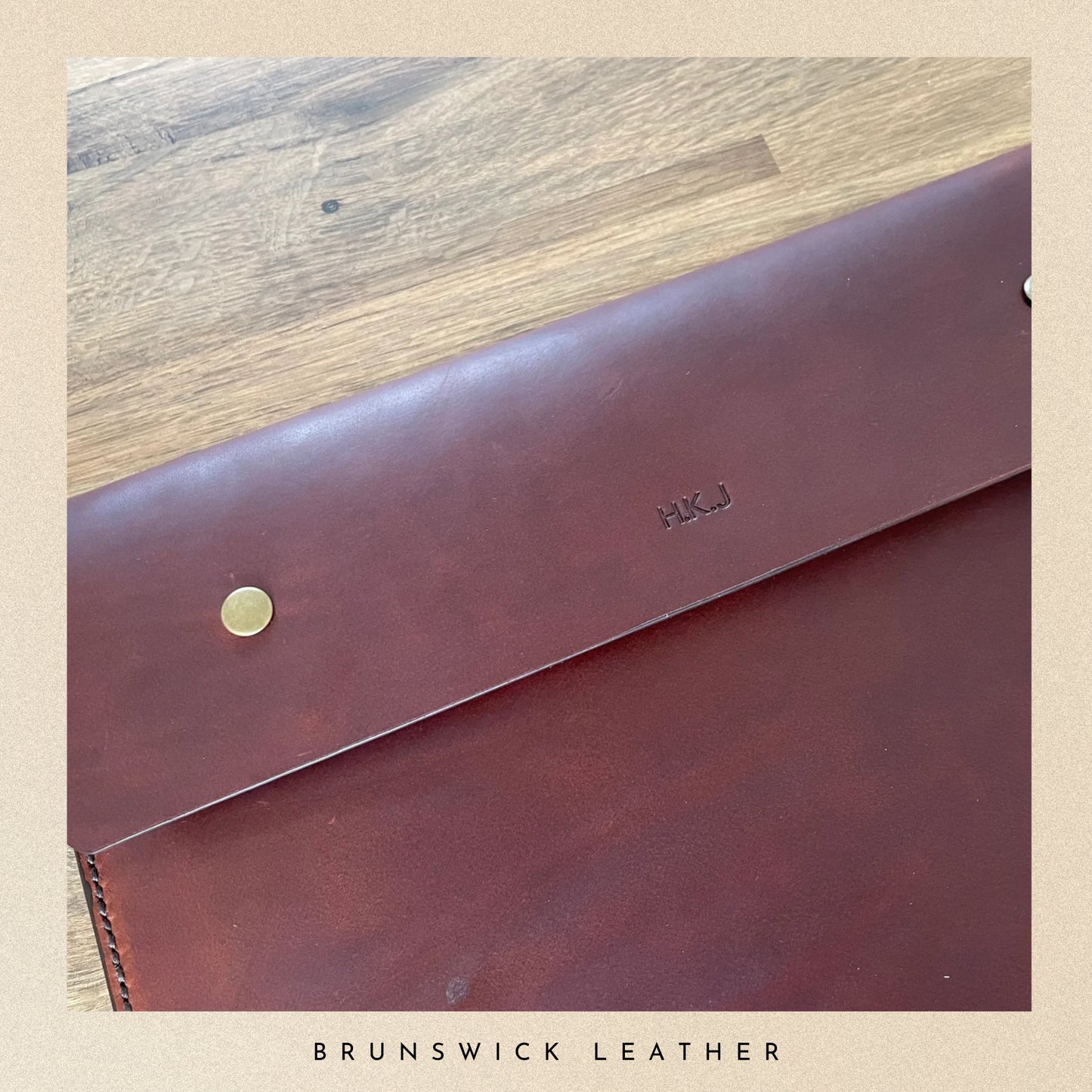 Brown leather wallet with 'HUK' branding on a wooden surface, branded 'Brunswick Leather'.