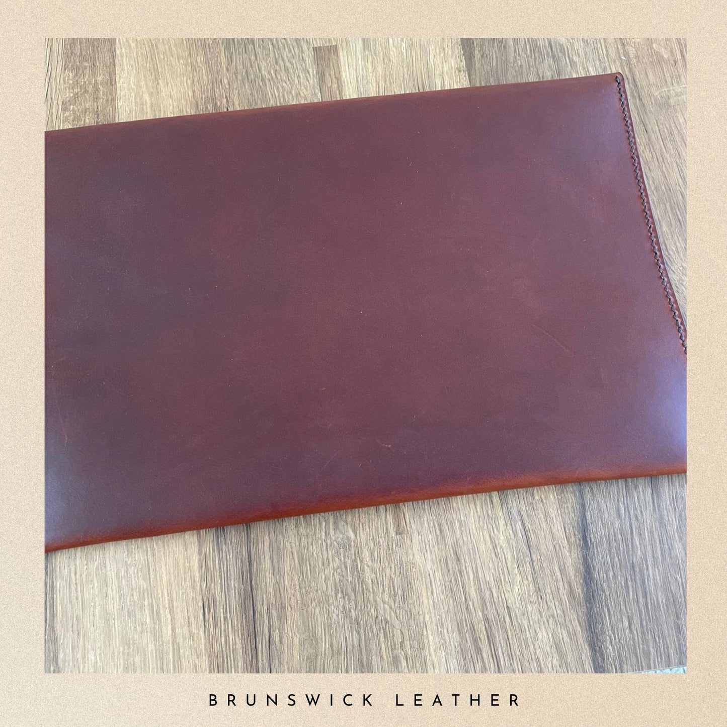 Brown leather wallet on a wooden surface with 'Brunswick Leather' branding.