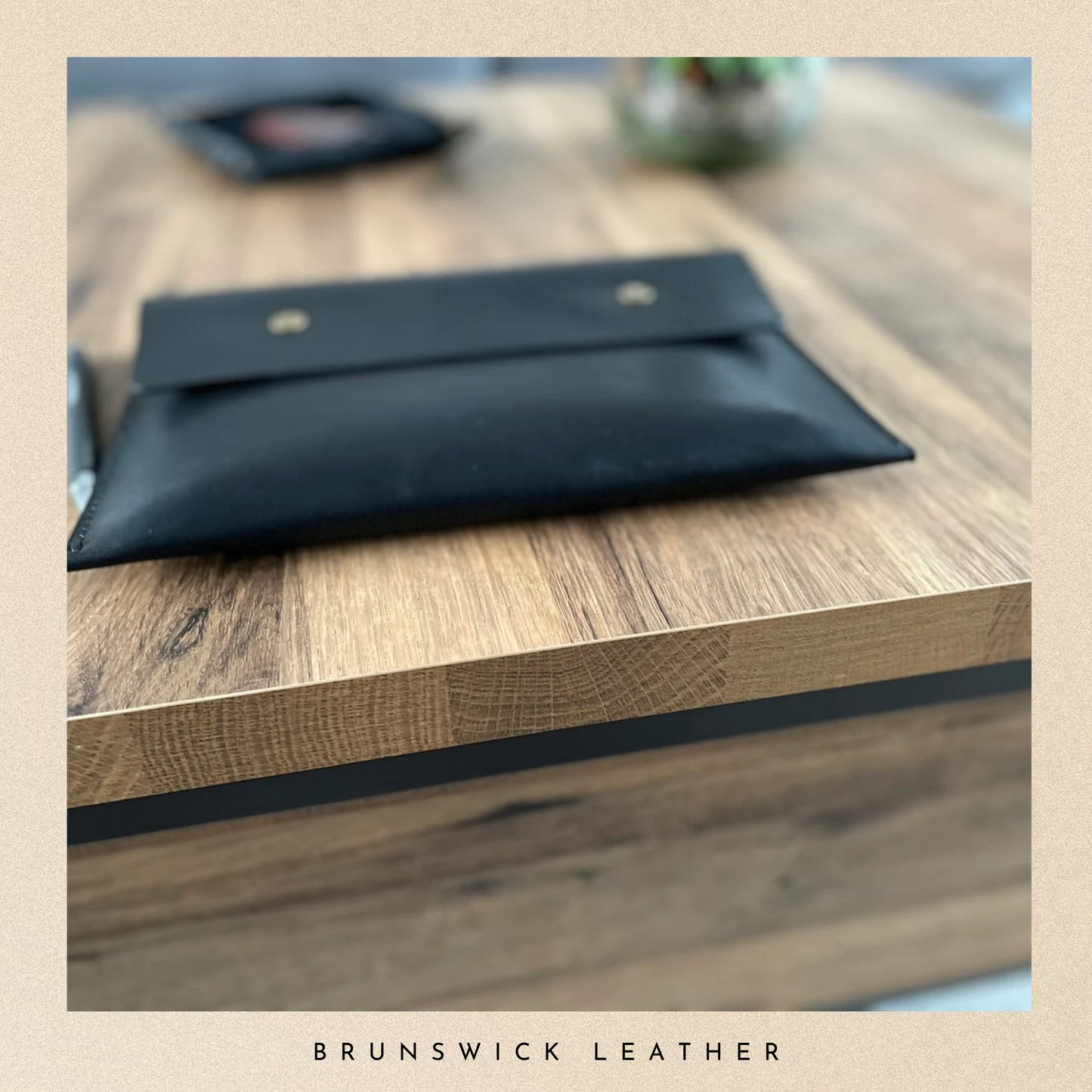 Black leather pouch on a wooden surface with 'Brunswick Leather' branding.