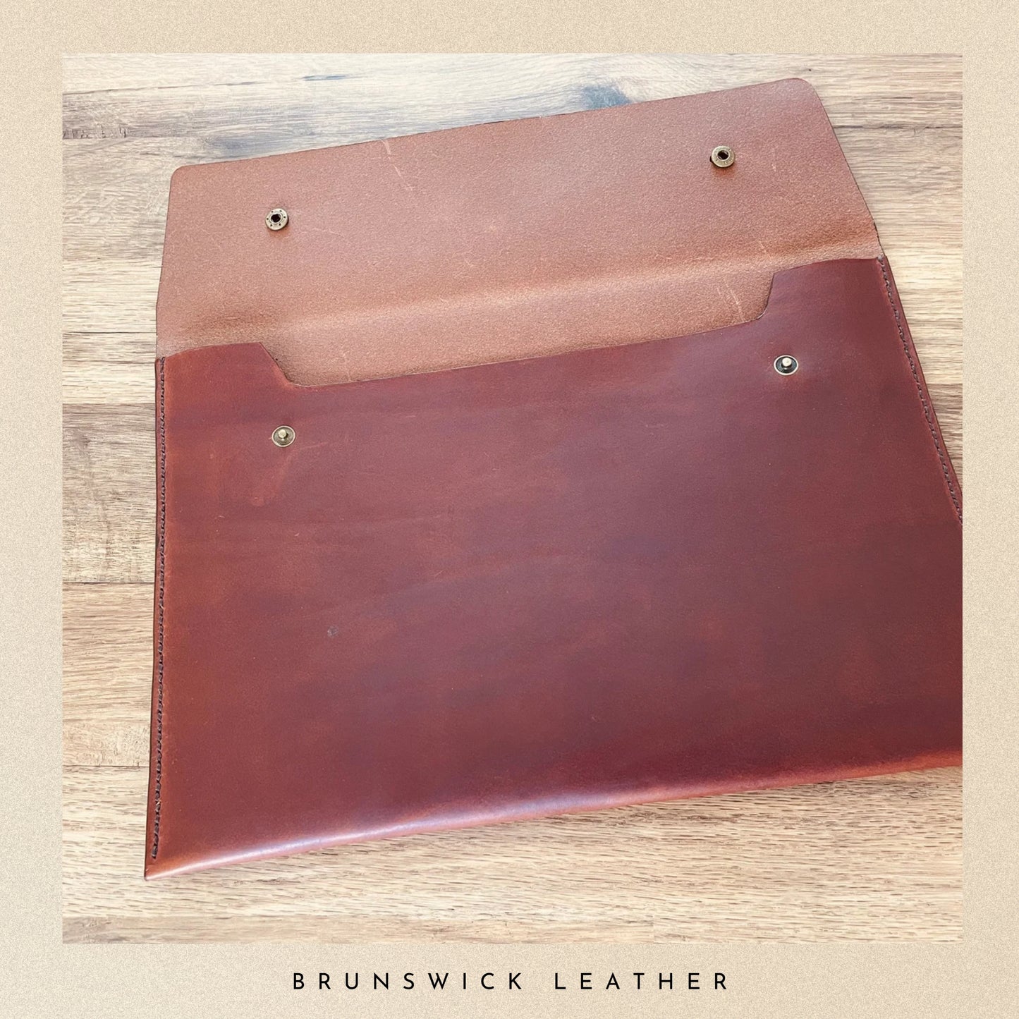 Brown leather pouch on a wooden surface with 'Brunswick Leather' branding.