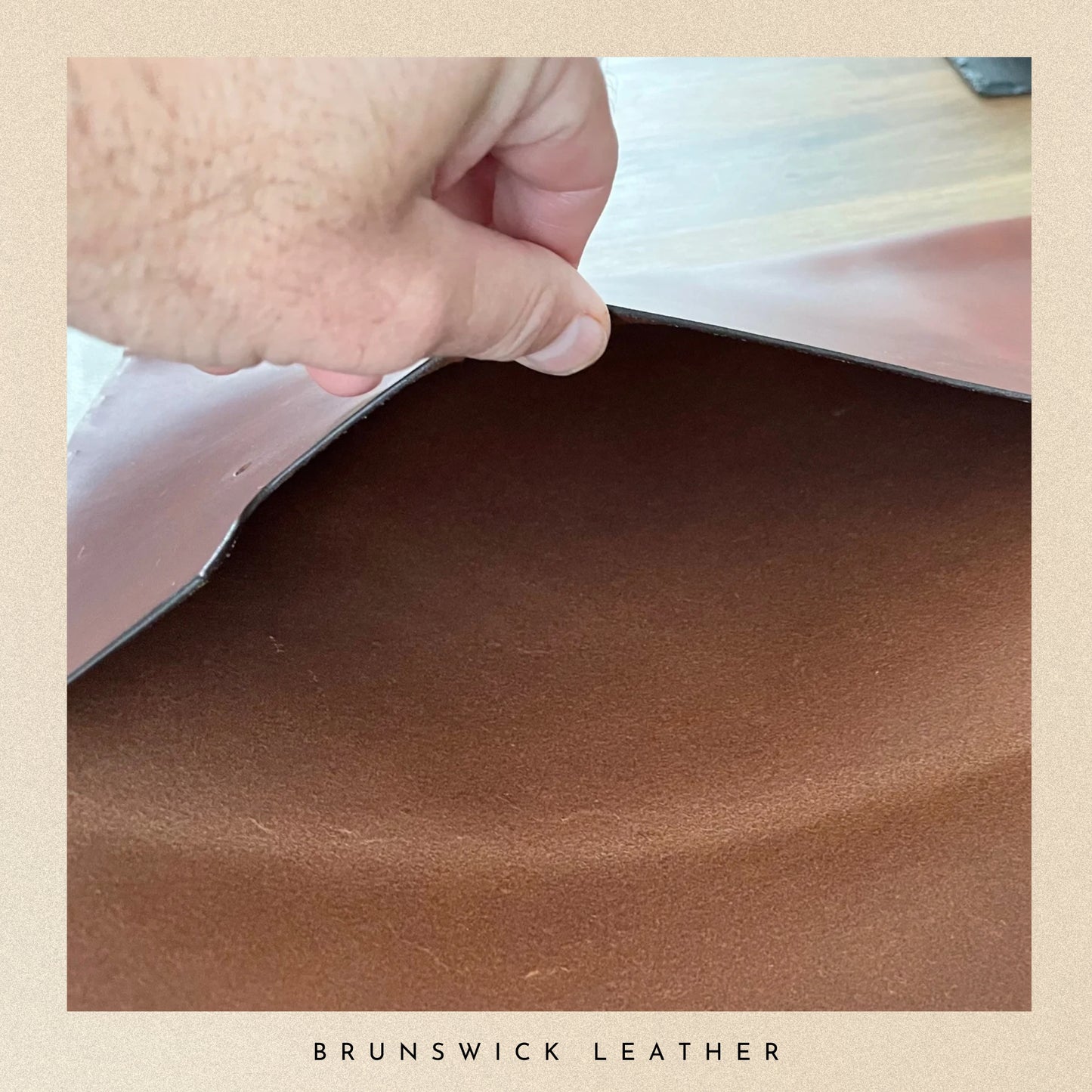 Close-up of brown leather with a hand pressing on it, branded 'Brunswick Leather'.