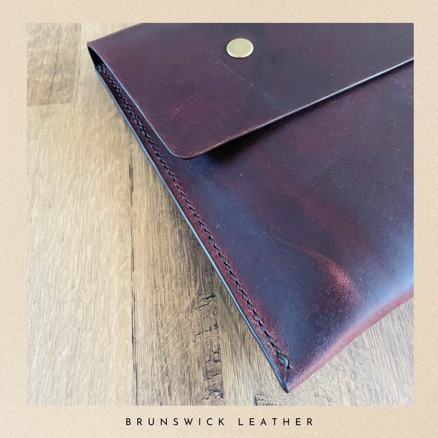 Brown leather wallet on a wooden surface with 'Brunswick Leather' branding.