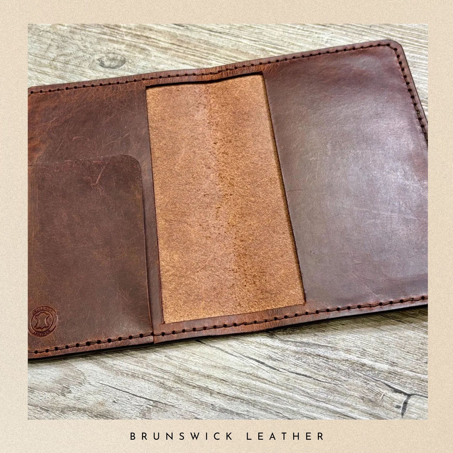 Brown leather wallet with visible stitching on a wooden surface, branded 'Brunswick Leather'.