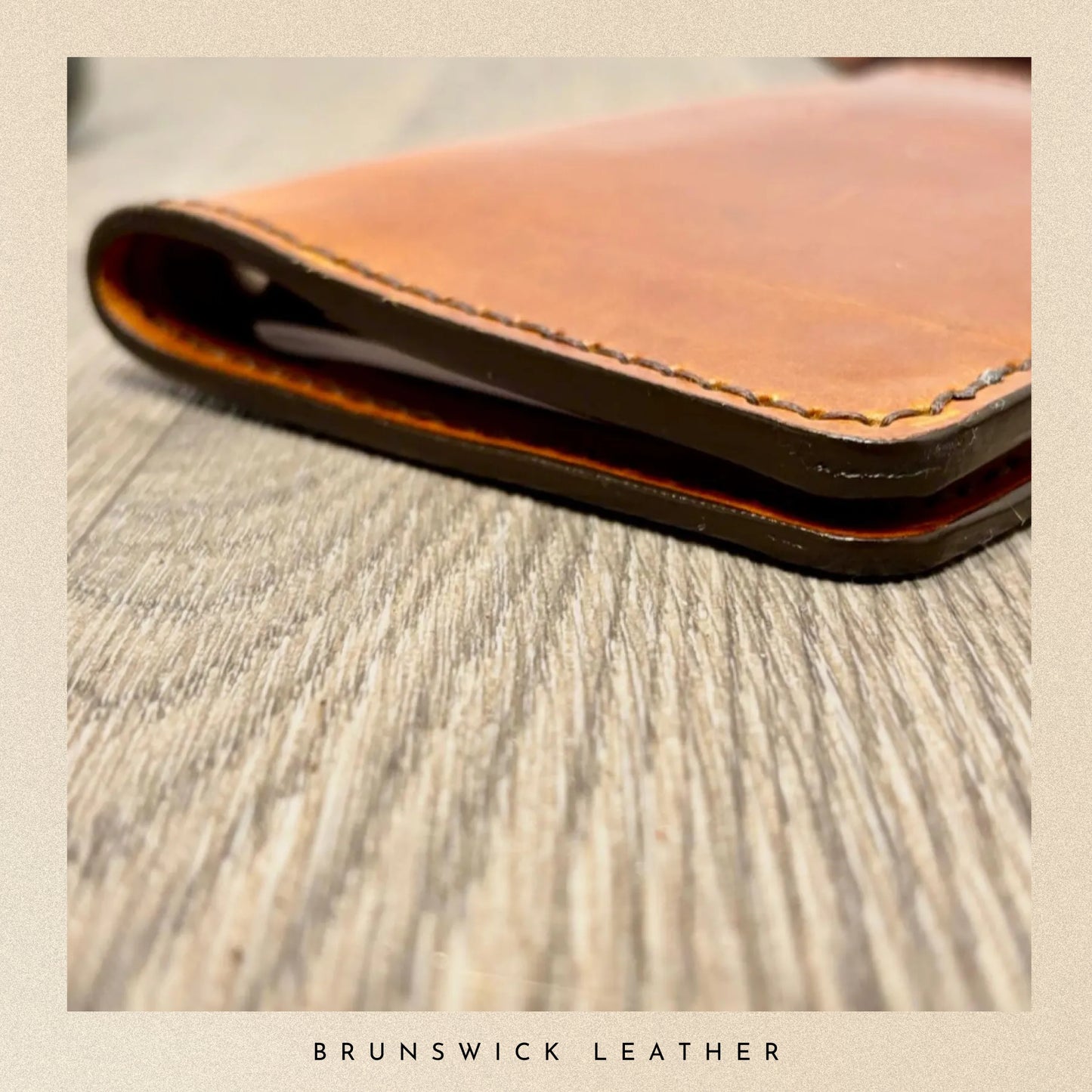 Brown leather wallet on a wooden surface with 'Brunswick Leather' branding.