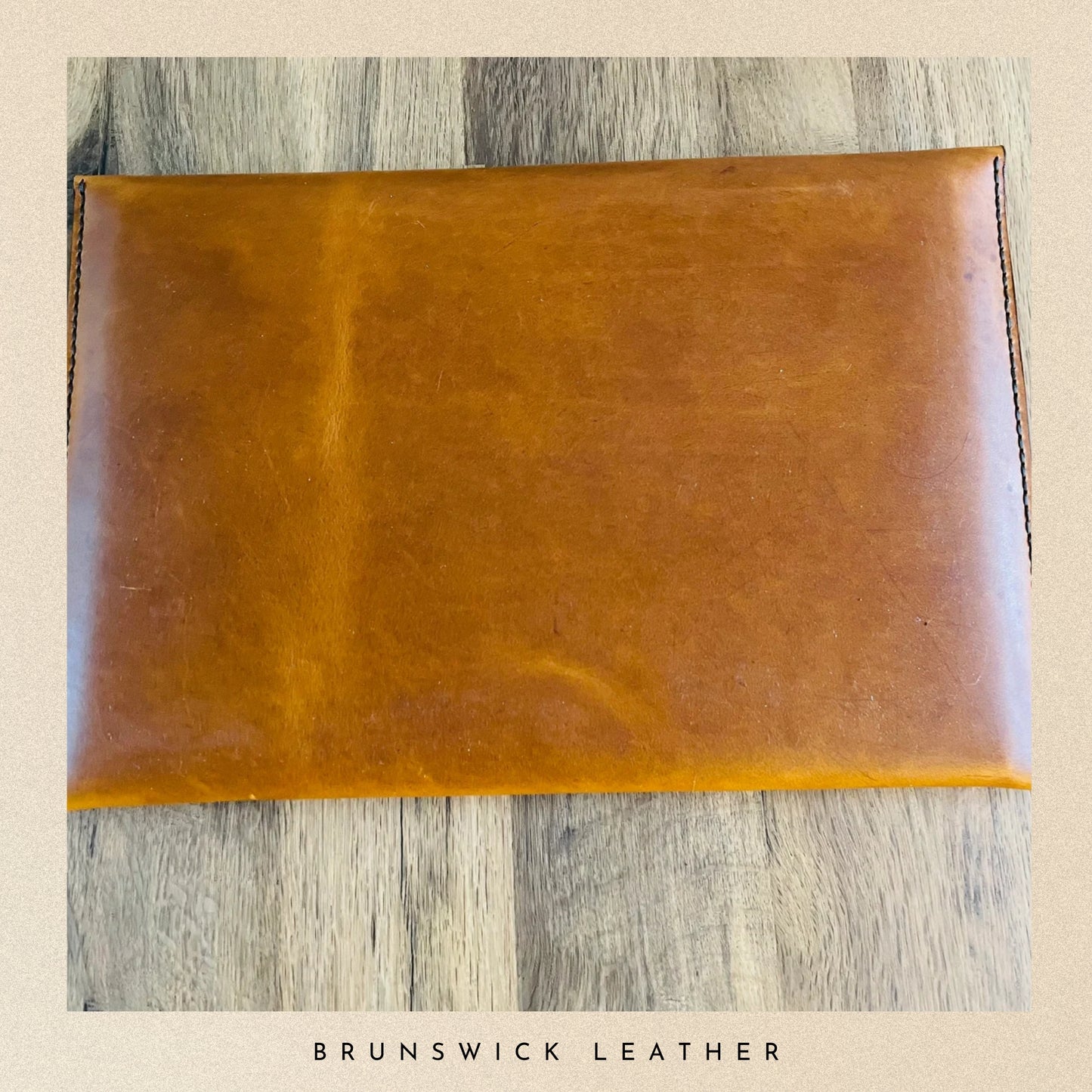 Brown leather pouch on a wooden surface with 'Brunswick Leather' branding.