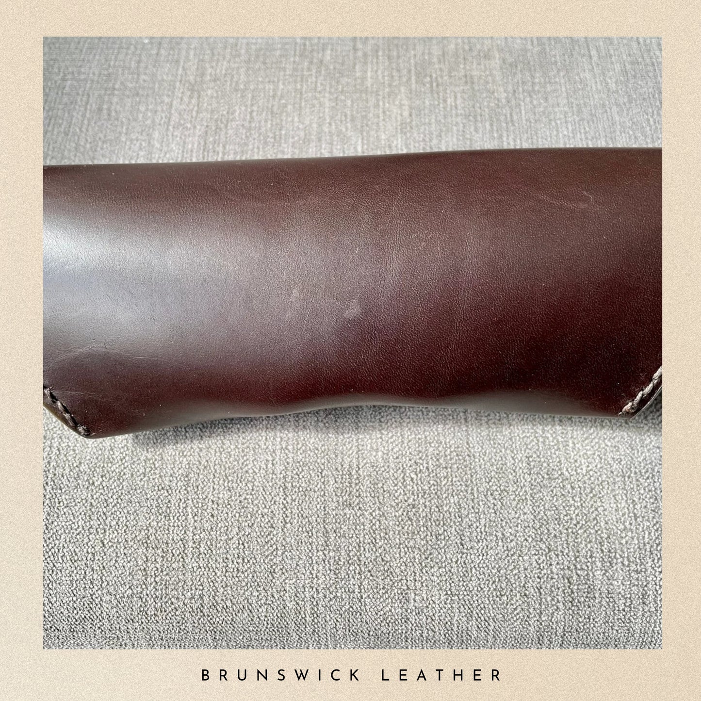 Brown leather roll on a textured gray surface with 'Brunswick Leather' branding.