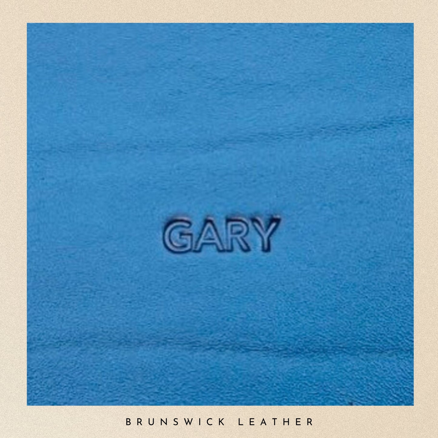Blue leather sample with 'GARY' embossed, branded 'Brunswick Leather'.