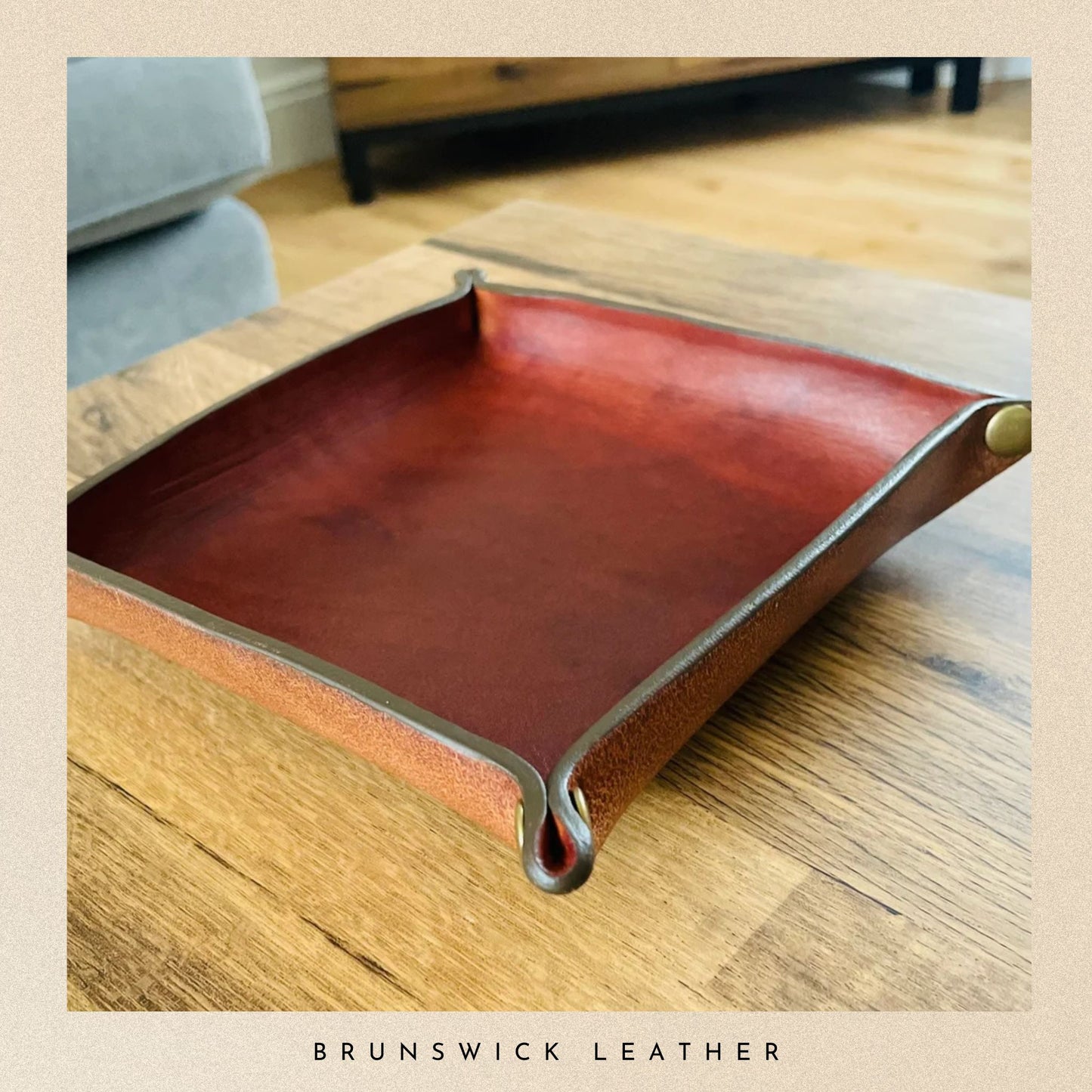 Brown leather tray on a wooden surface with 'Brunswick Leather' branding.