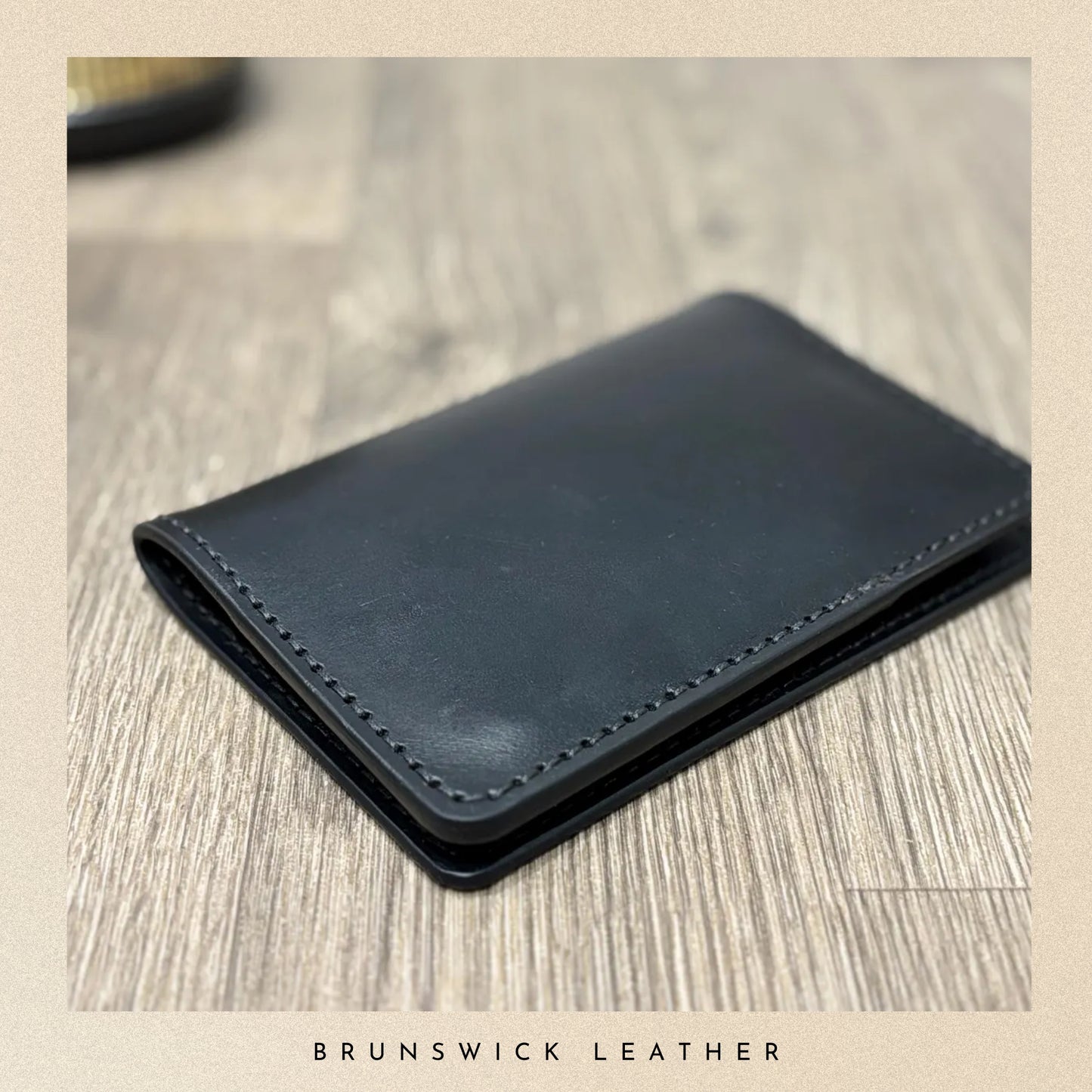 Blue leather wallet on a wooden surface with 'Brunswick Leather' branding.