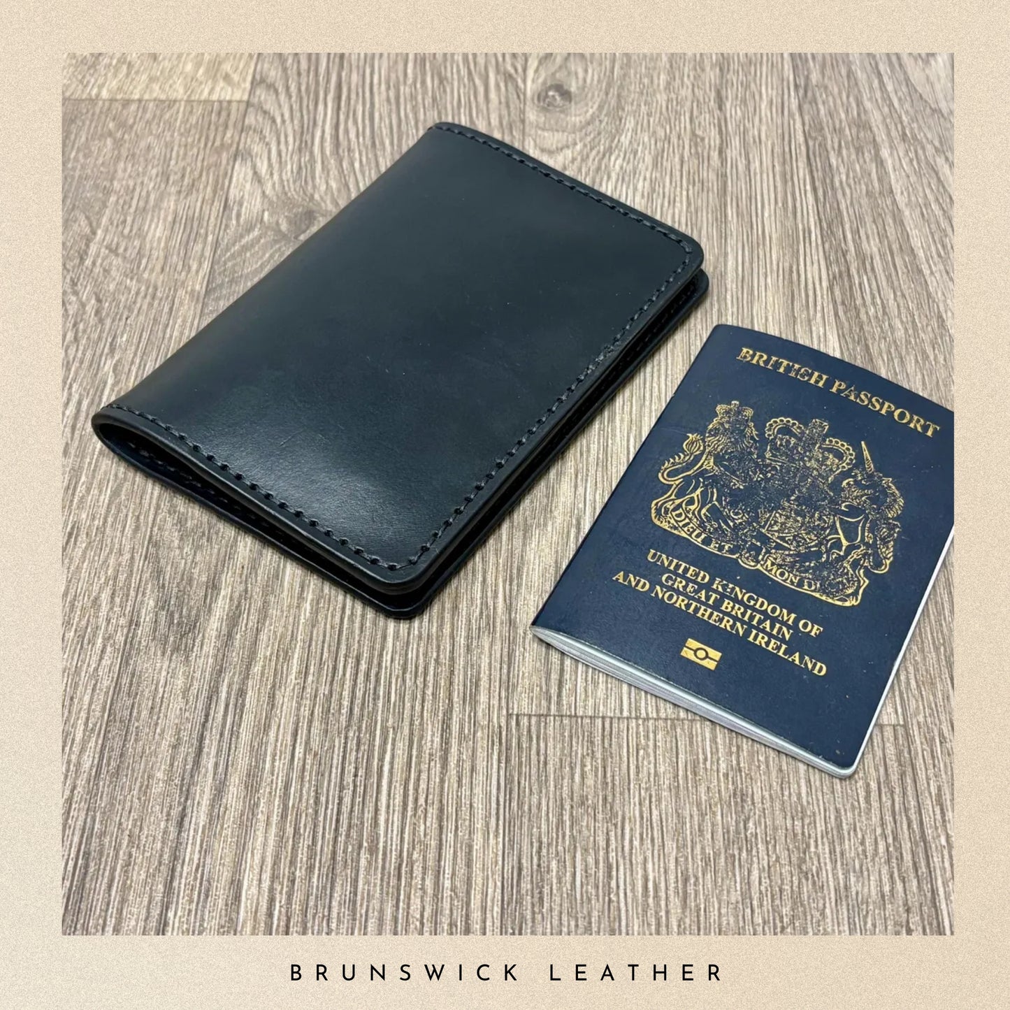 Blue leather wallet and British passport on a wooden surface with 'Brunswick Leather' branding.