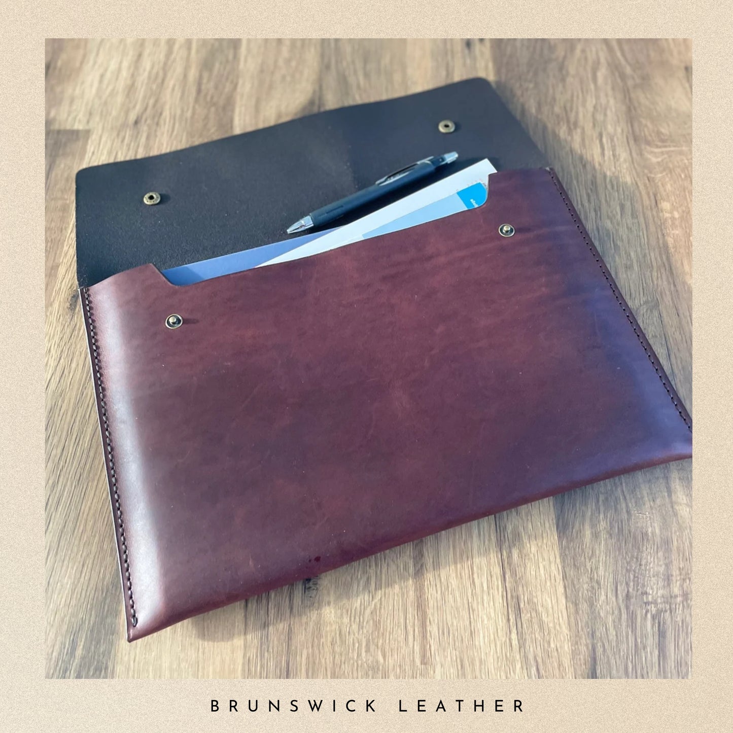 Brown leather wallet with card slots on a wooden surface, branded 'Brunswick Leather'.
