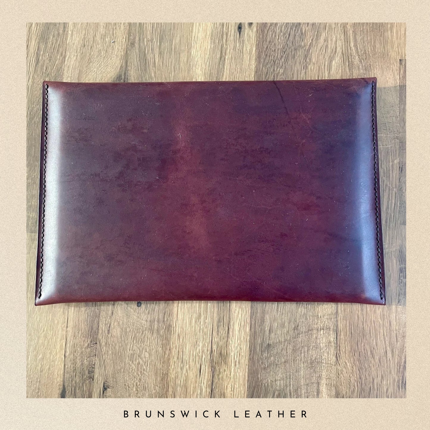Brown leather wallet on a wooden surface with 'Brunswick Leather' branding.