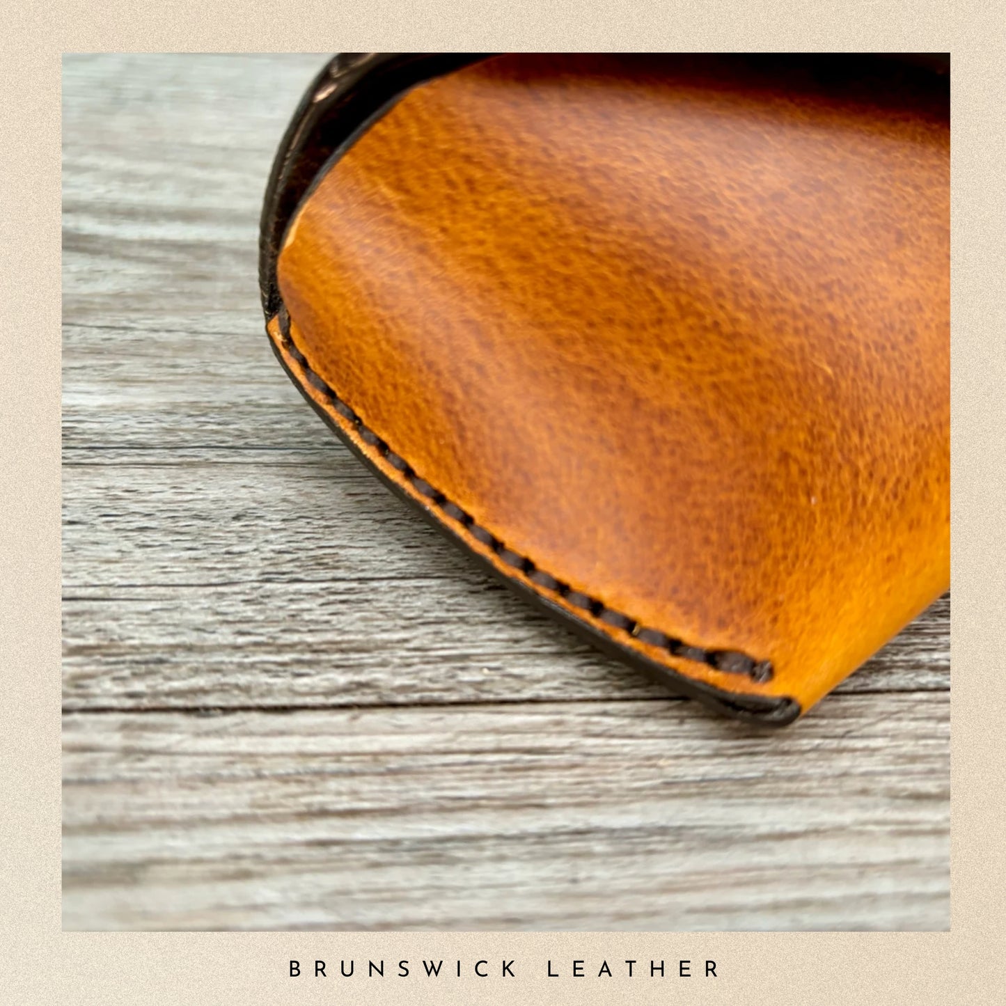 Close-up of a brown leather product on a wooden surface with 'Brunswick Leather' branding.