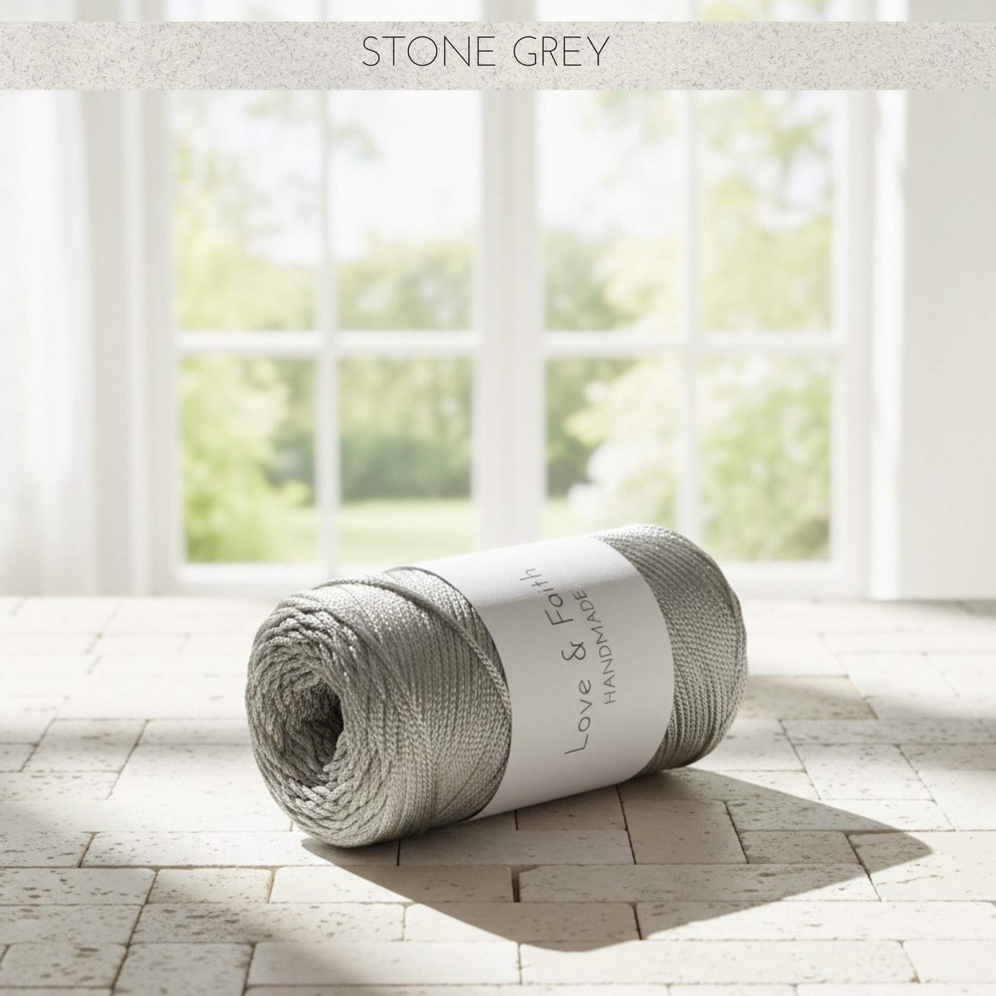 Roll of stone grey yarn with a label on a wooden floor in a bright room