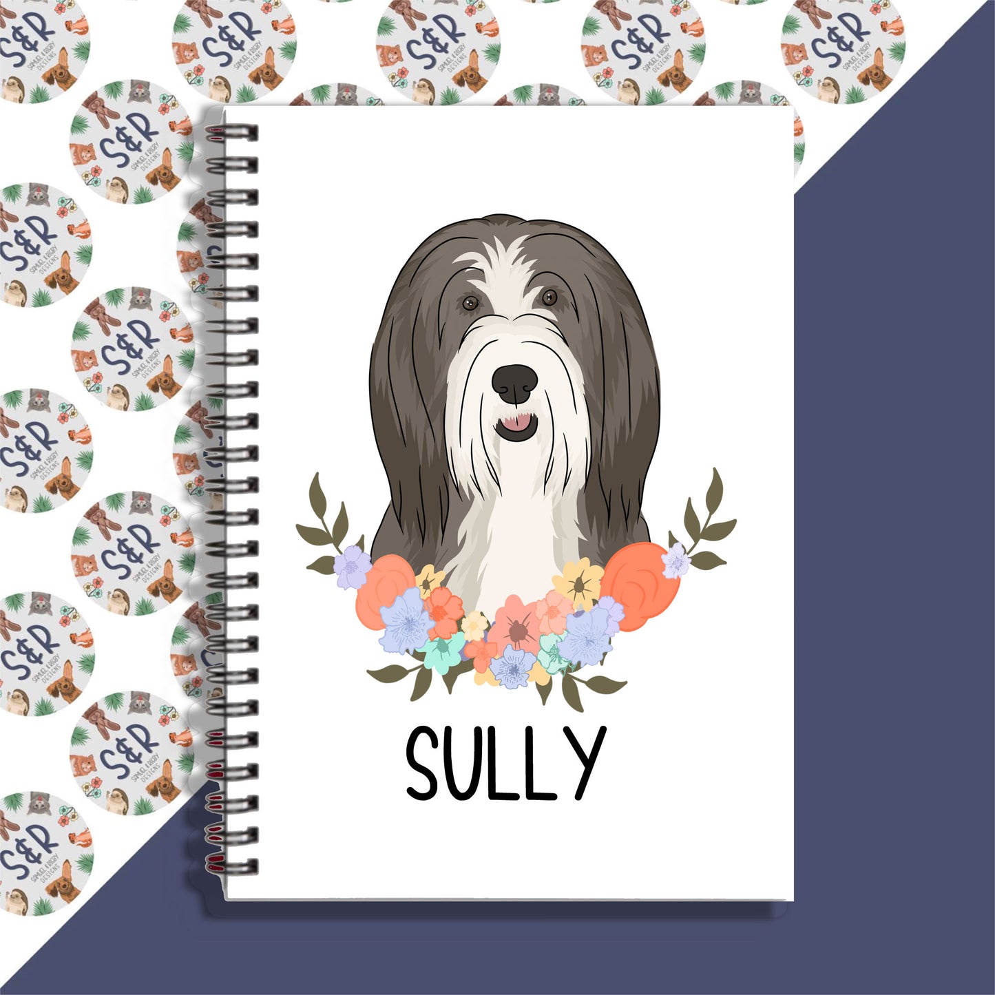 A personalised notebook featuring a graphic of a bearded collie dog on the cover, with a floral pattern in the background.