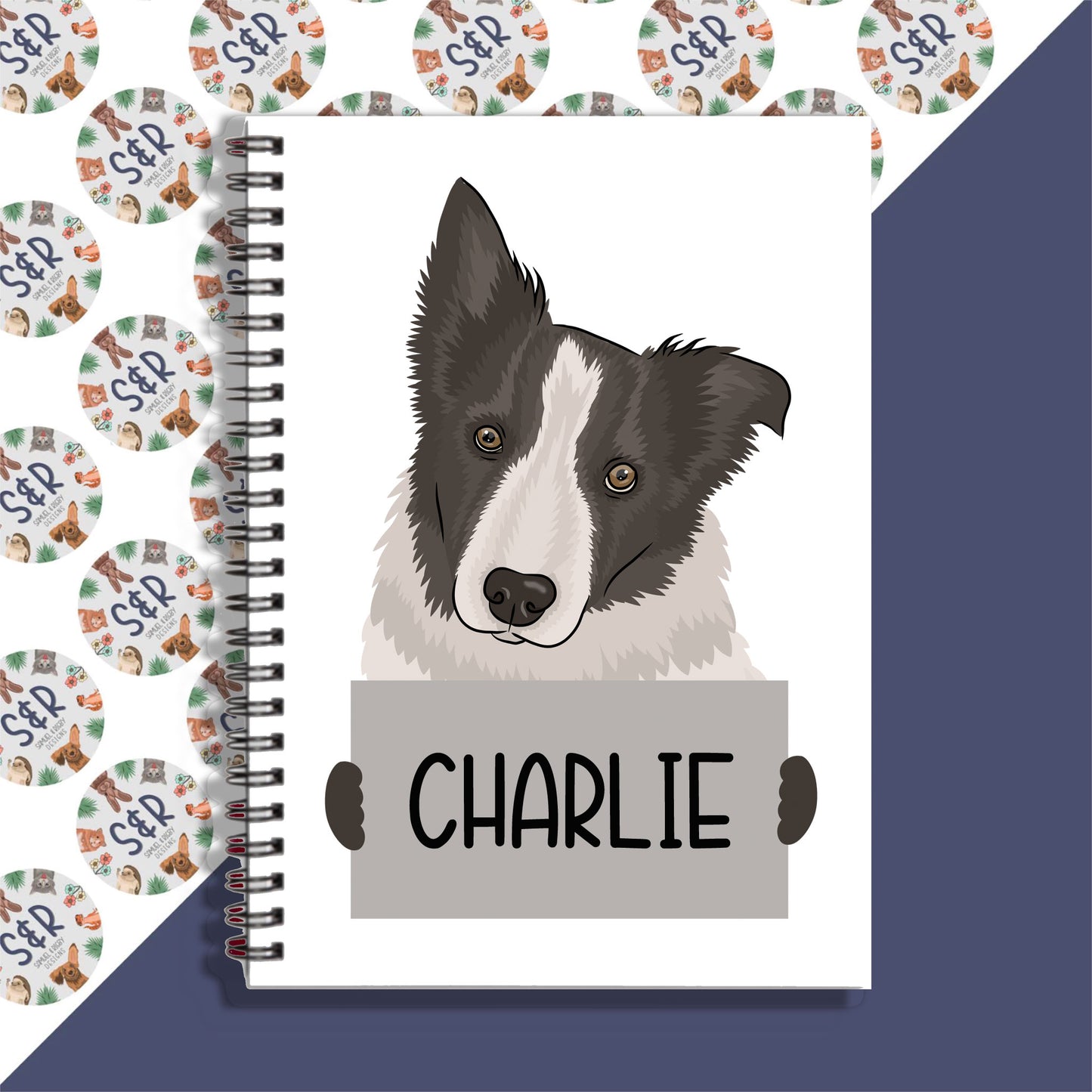 A personalised notebook with a graphic of a Border Collie dog on the front cover, with the name 'Charlie' written on the front.