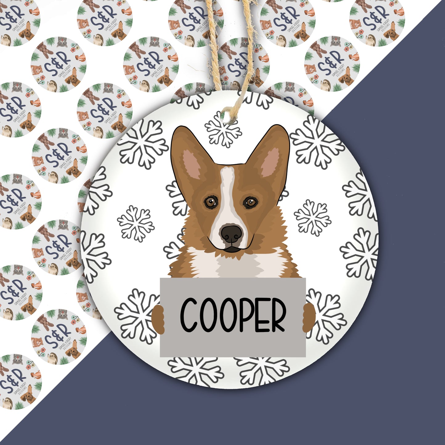 A ceramic Christmas decoration featuring a cartoon corgi dog with the name 'Cooper' on a tag, set against a white snowy background.