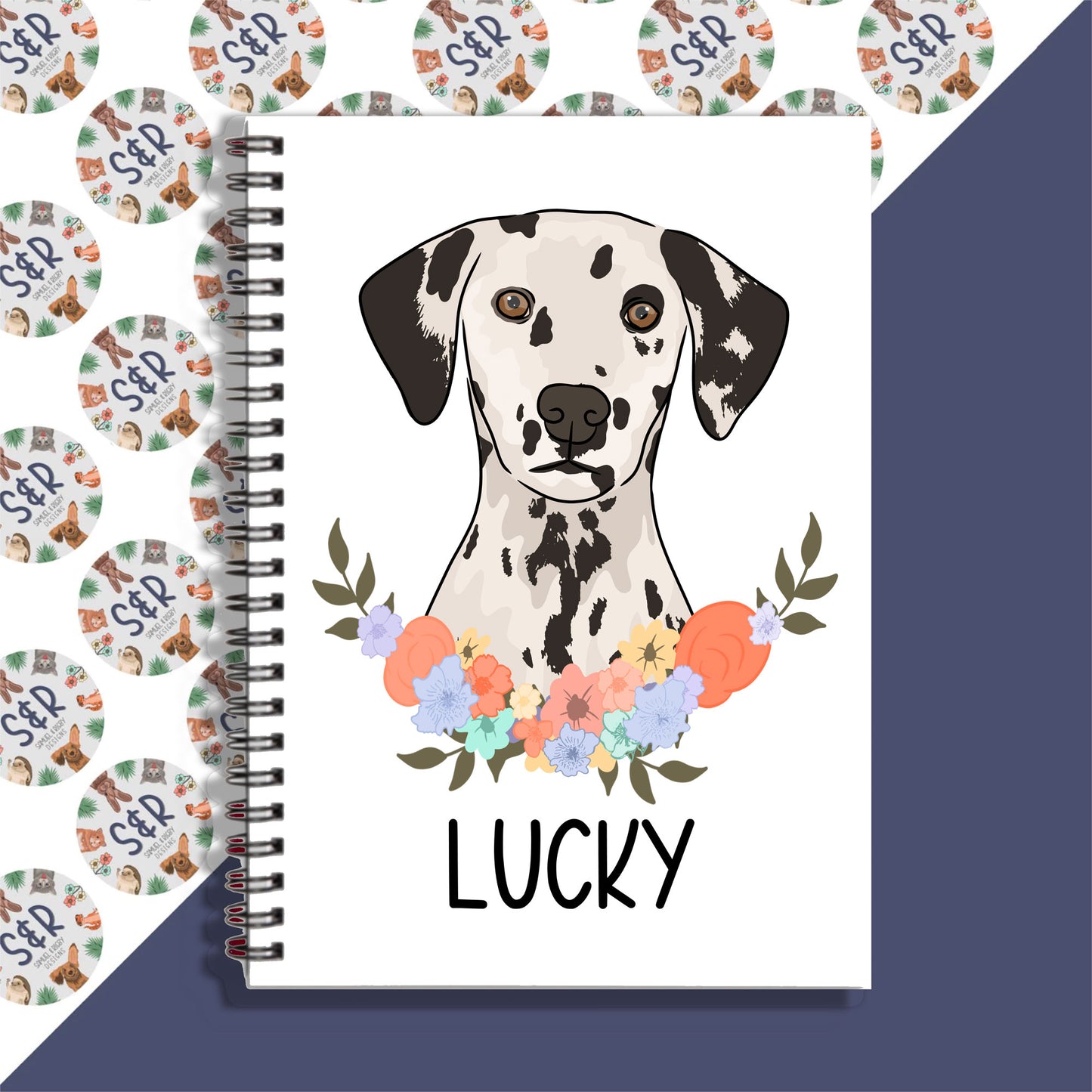 A personalised notebook with a spiral binding featuring a graphic of a Dalmatian dog on the front cover, with the name 'Lucky' written on the page.