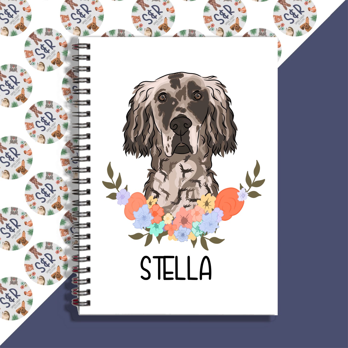 A personalised notebook with a drawing of an English Setter dog on the cover, surrounded by floral designs with the name 'Stella' written inside.