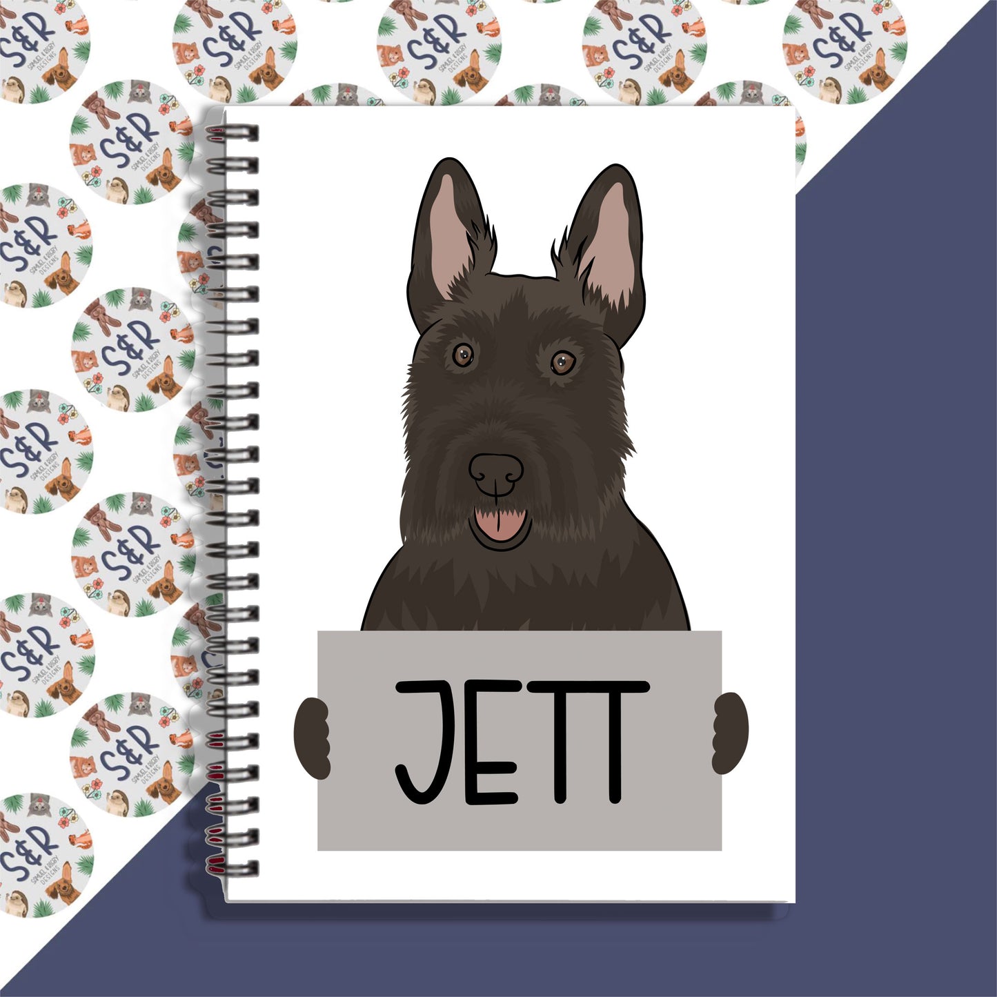 A notebook with a spiral binding featuring a graphic of a Scottish Terrier dog on the front cover, with the name 'JETT' written on the cover.