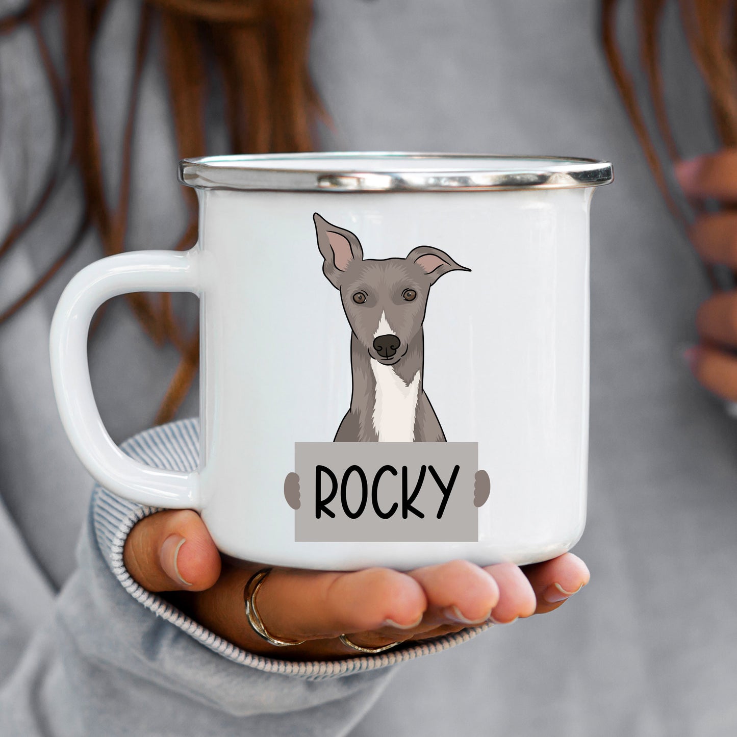 A white ceramic enamel mug with an illustration of a whippet dog and the name 'Rocky' printed on it.