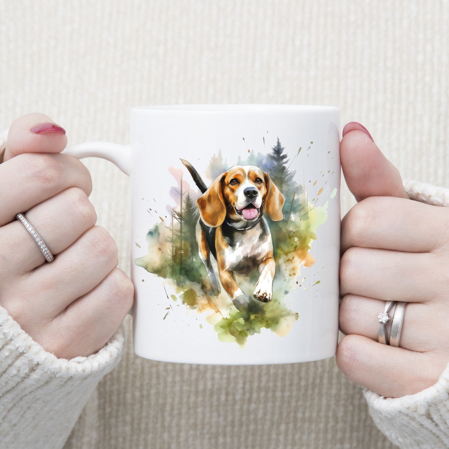 A Beagle dog is running forward through a forest setting on a  white ceramic mug. A woman is holding the mug with both hands.