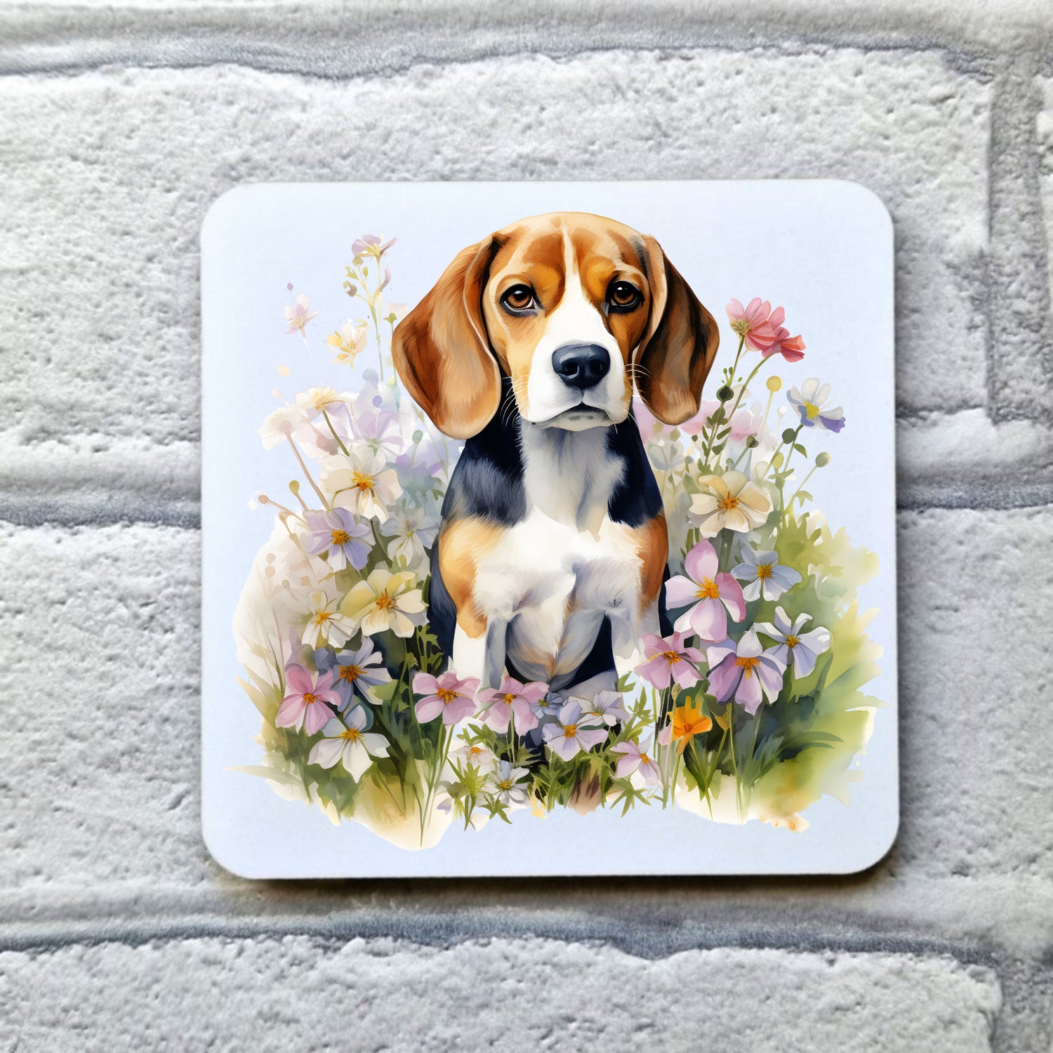 A white coaster with a Beagle dog sat among pink and white spring wildflowers. The coaster is placed on a grey, brick effect surface.